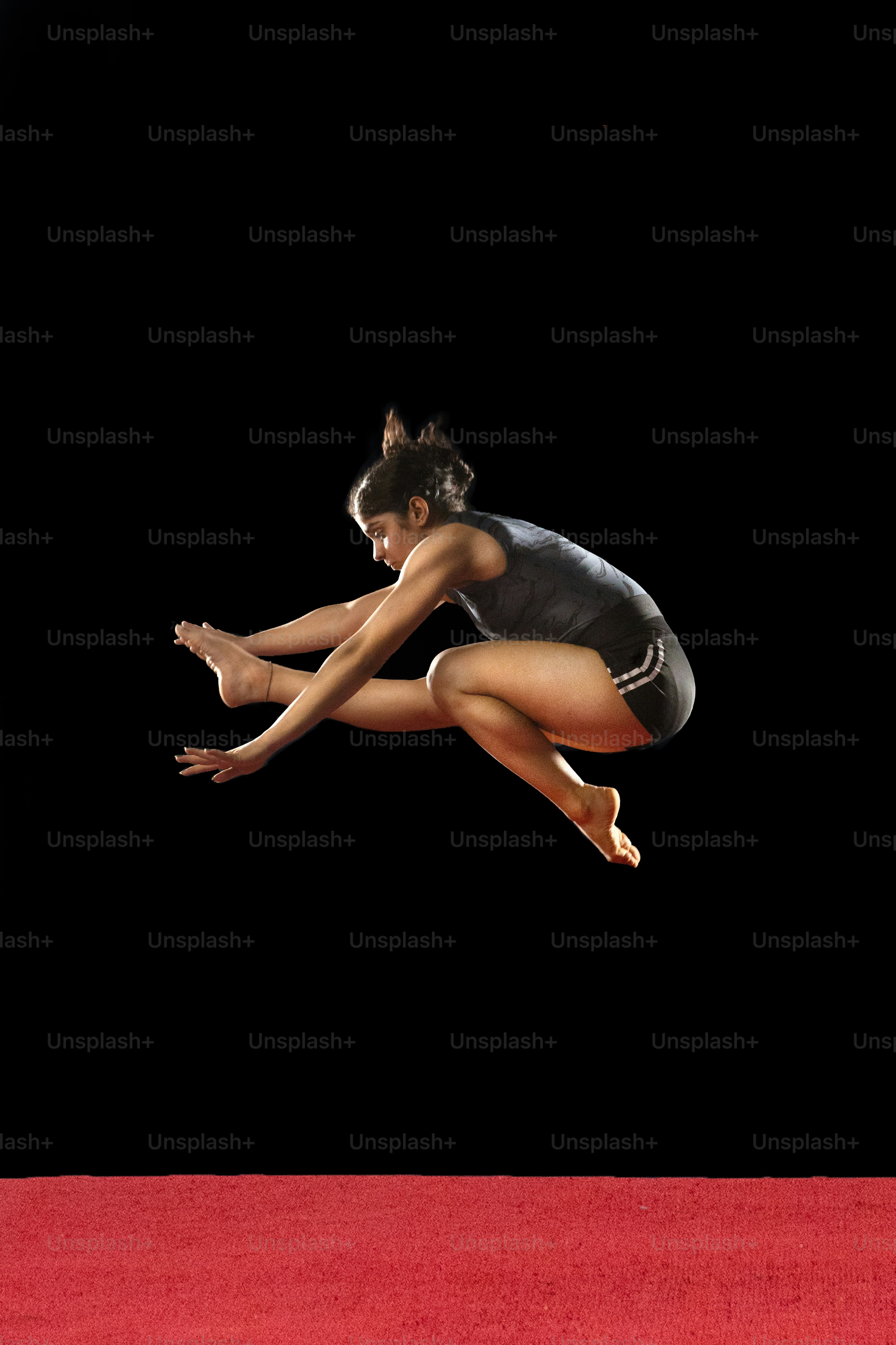 A woman jumping in the air on a red carpet