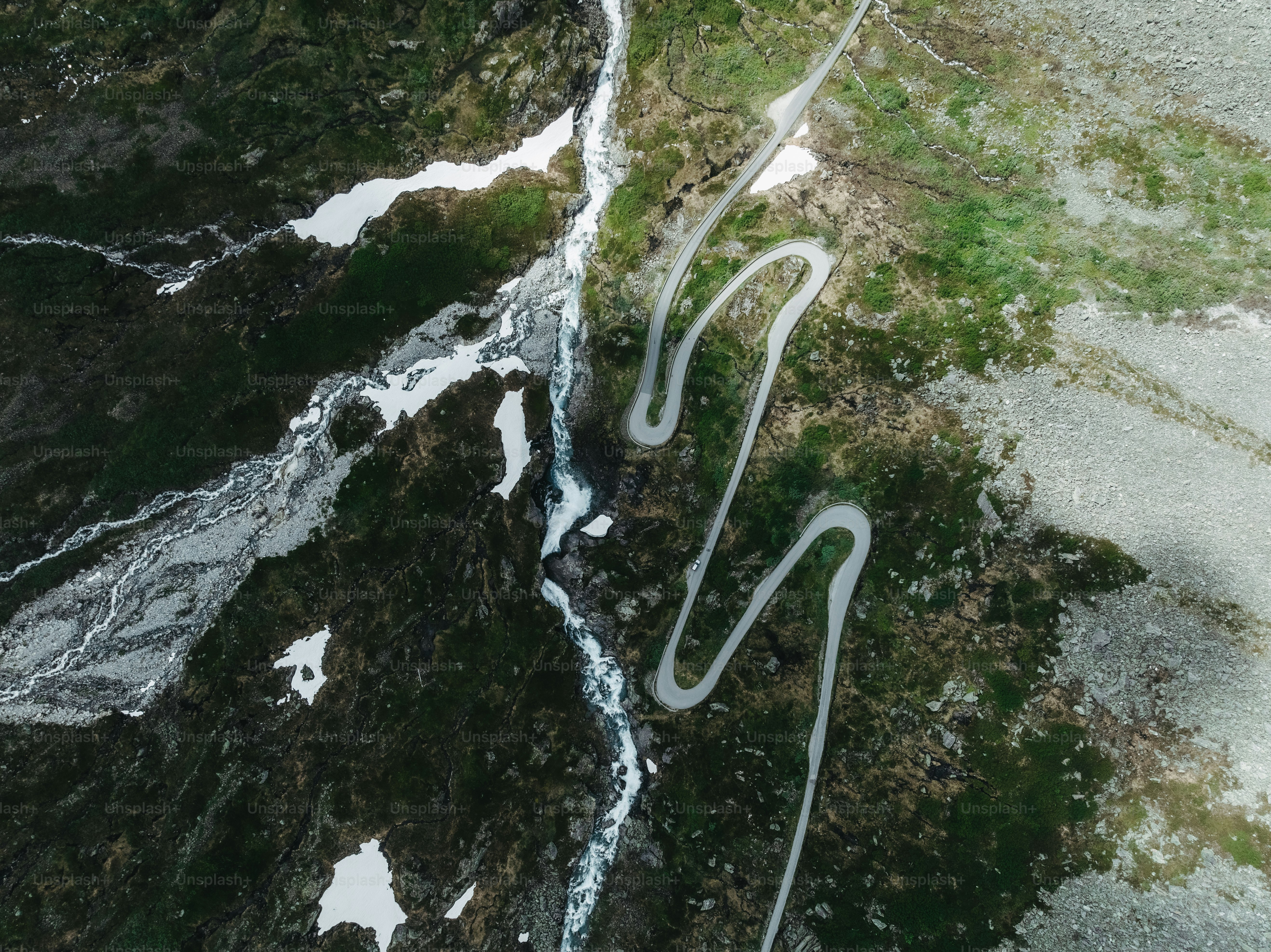 An aerial view of a winding road in the mountains