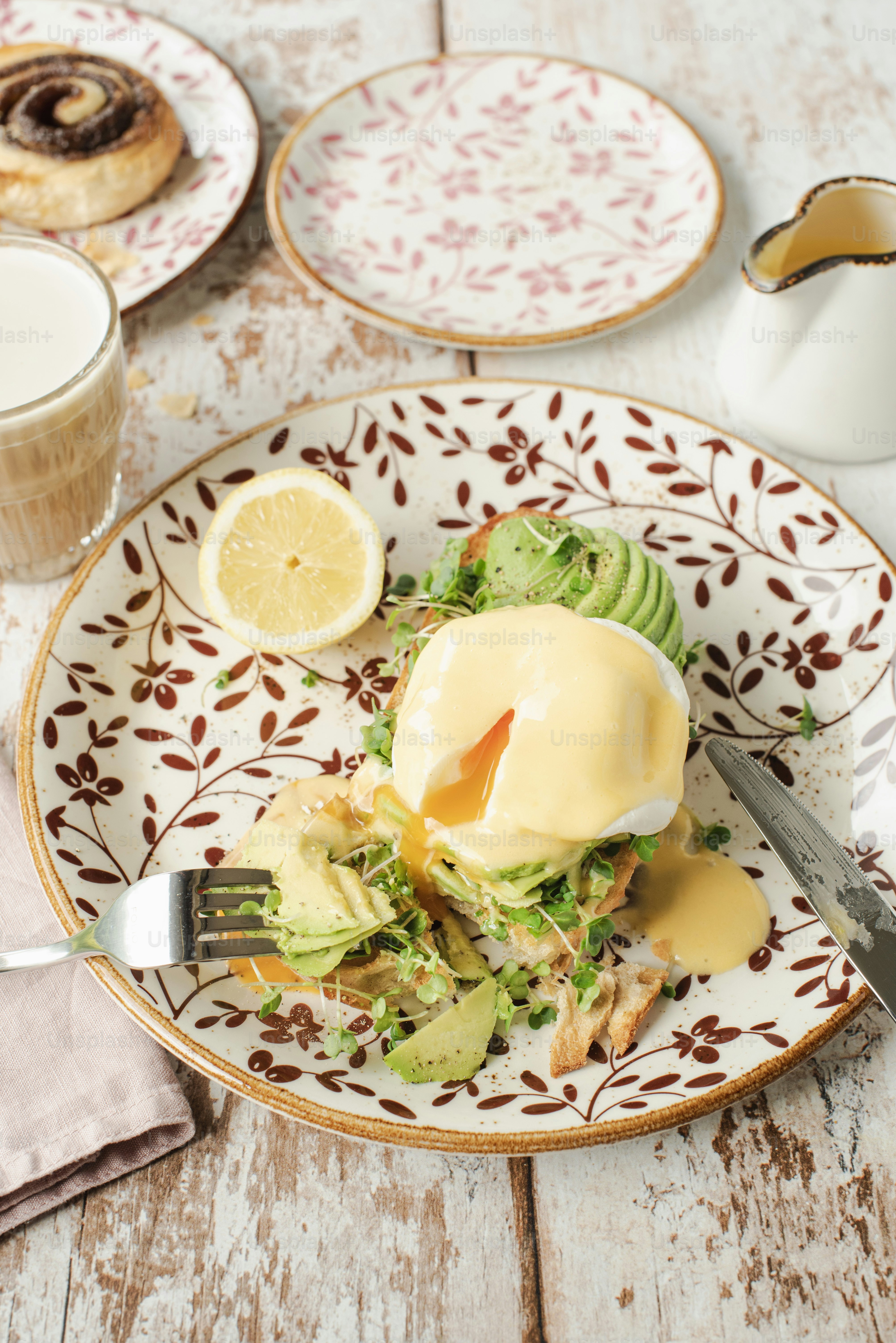 A plate with a sandwich on it next to a cup of coffee