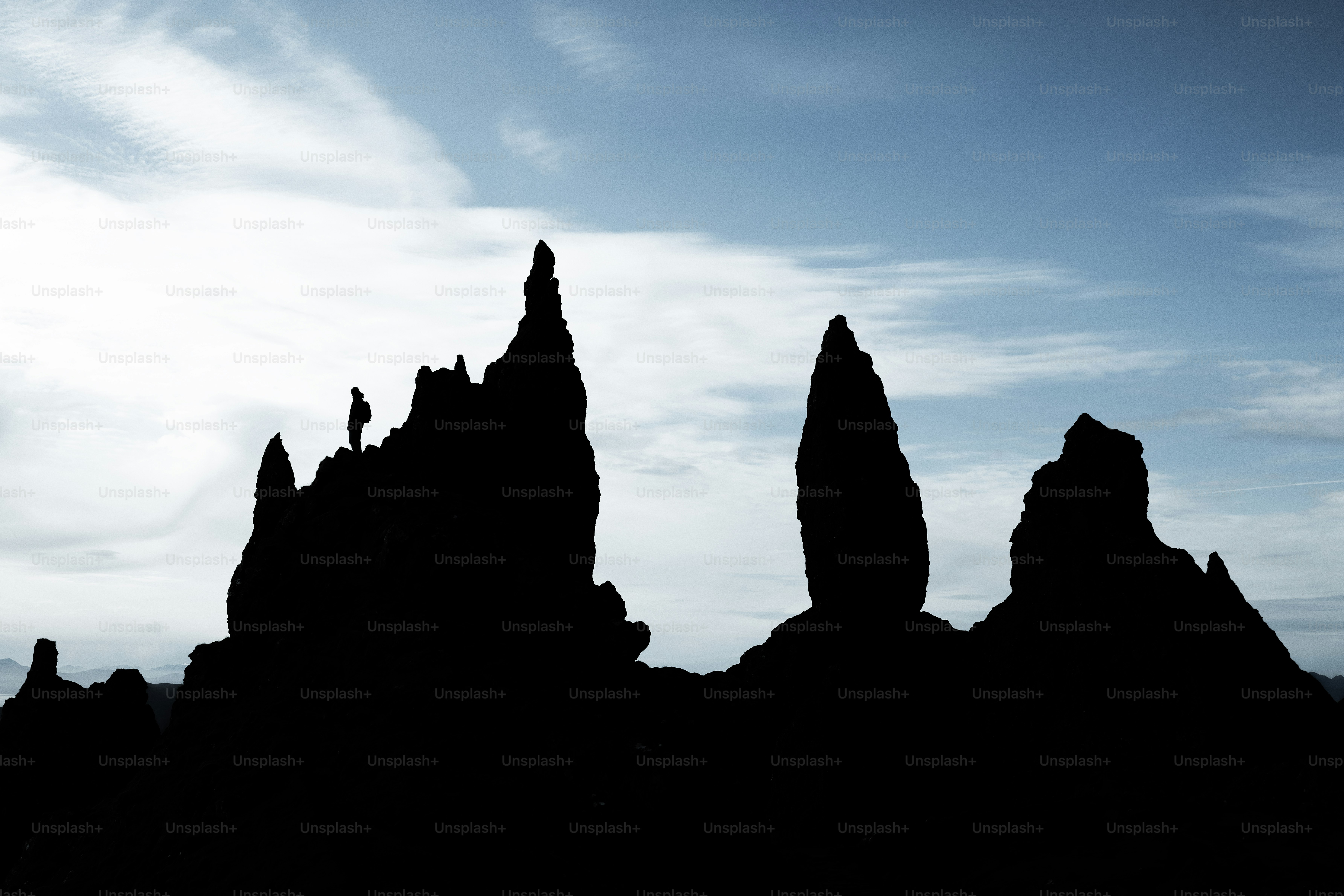 The silhouette of a group of rocks against a blue sky