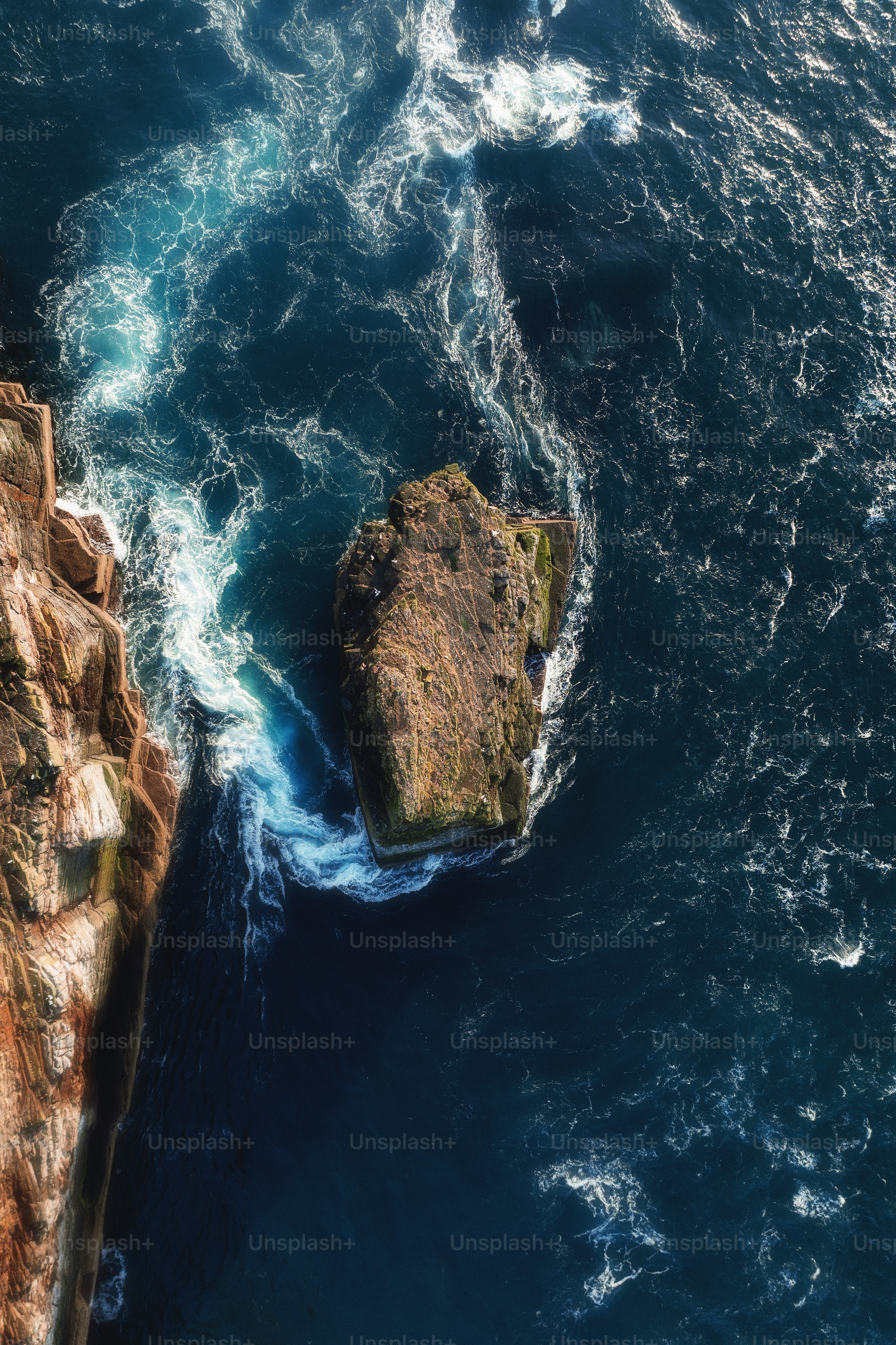 An aerial view of the ocean and rocks