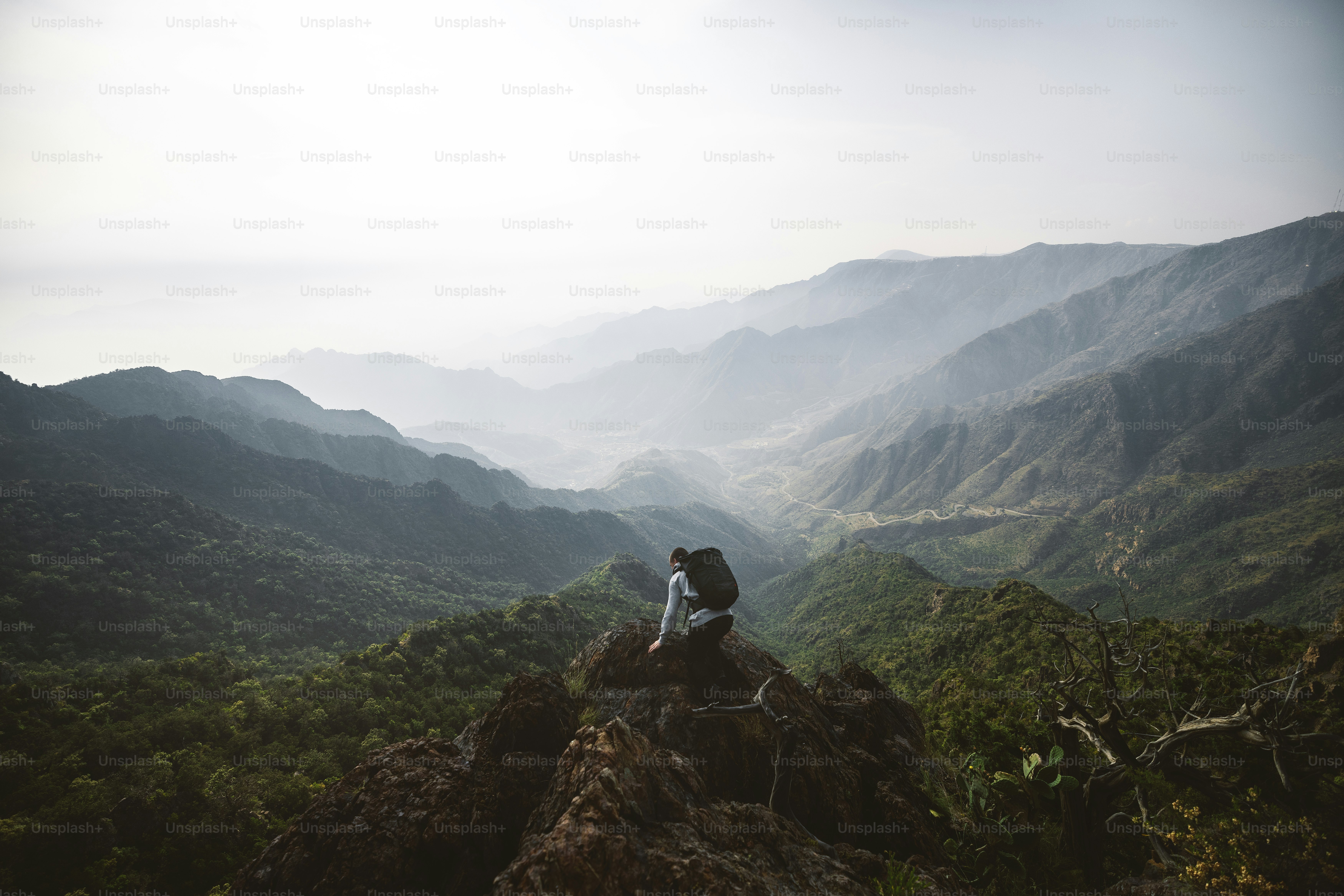 A person sitting on top of a rock in the mountains