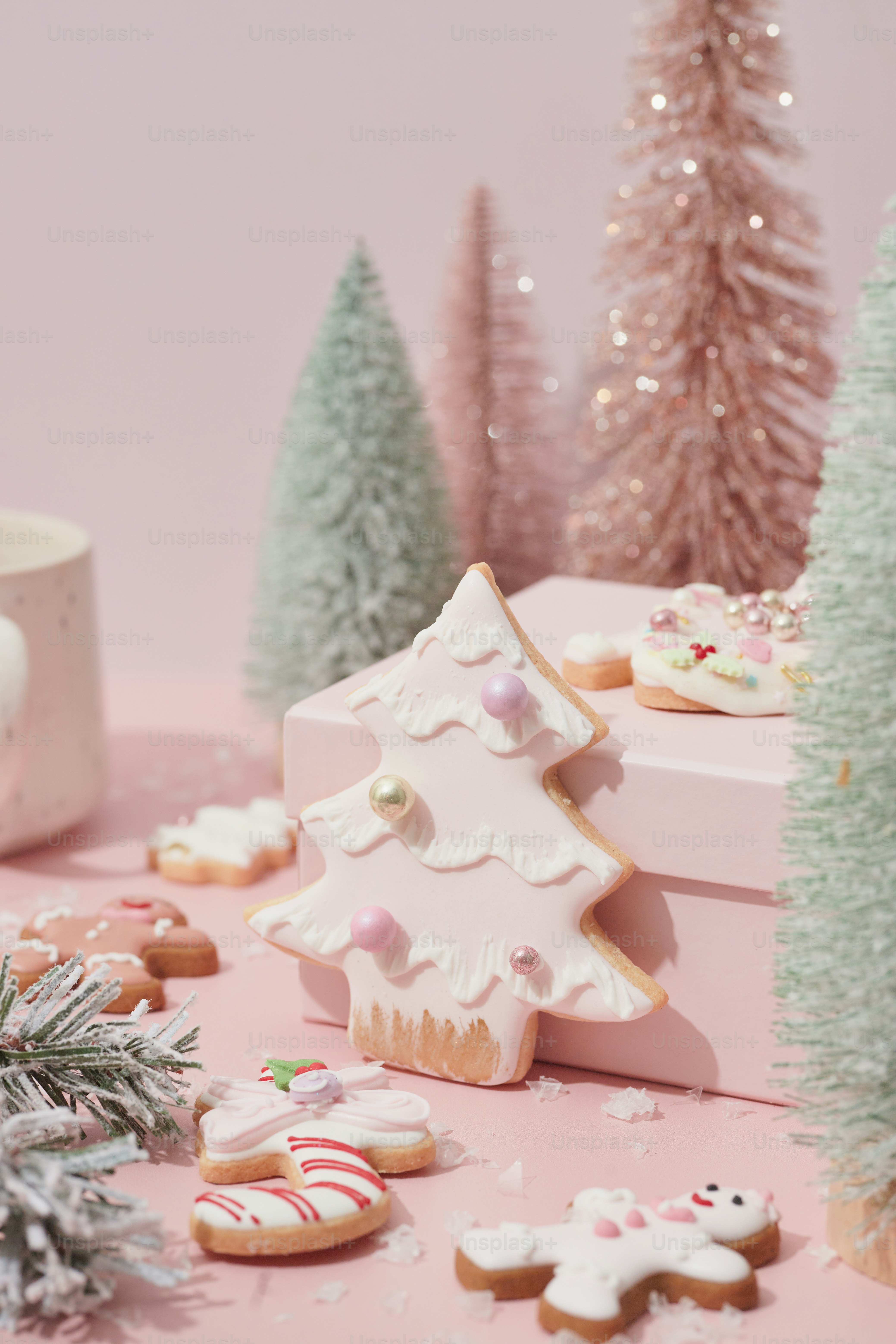 A pink table topped with christmas cookies and a cup of coffee