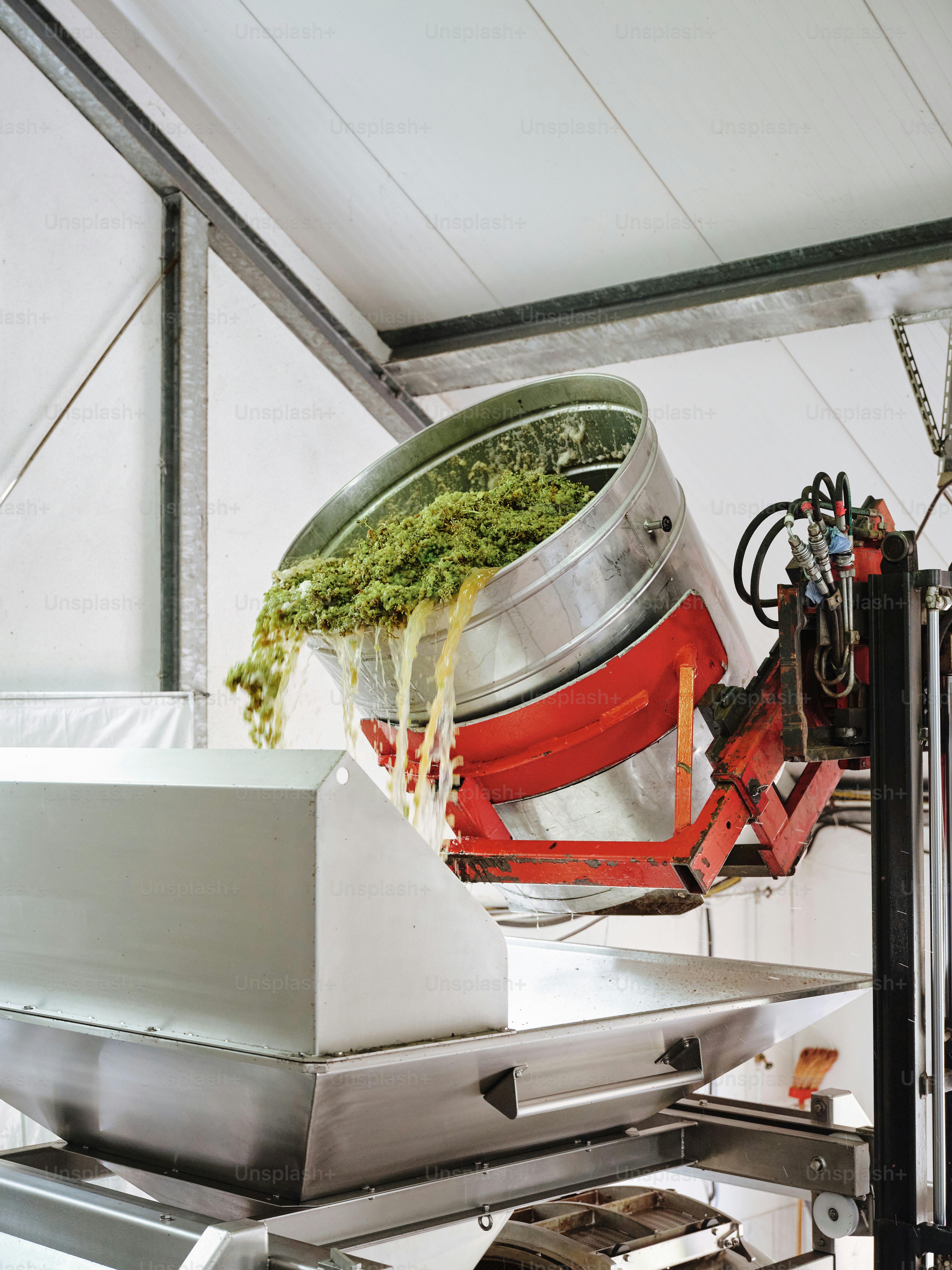A large metal container filled with food on top of a conveyor belt