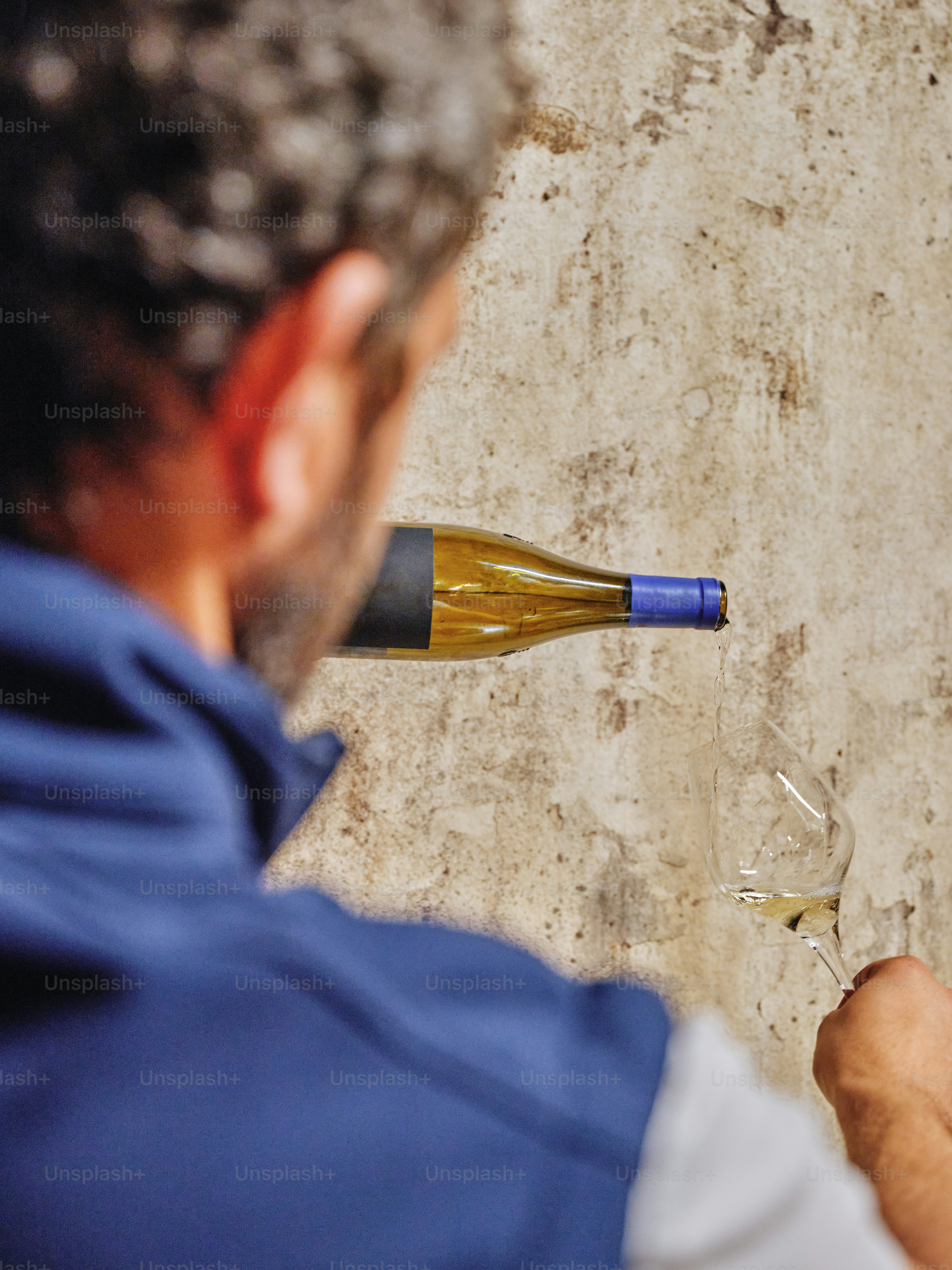 A man holding a wine glass and a bottle of wine