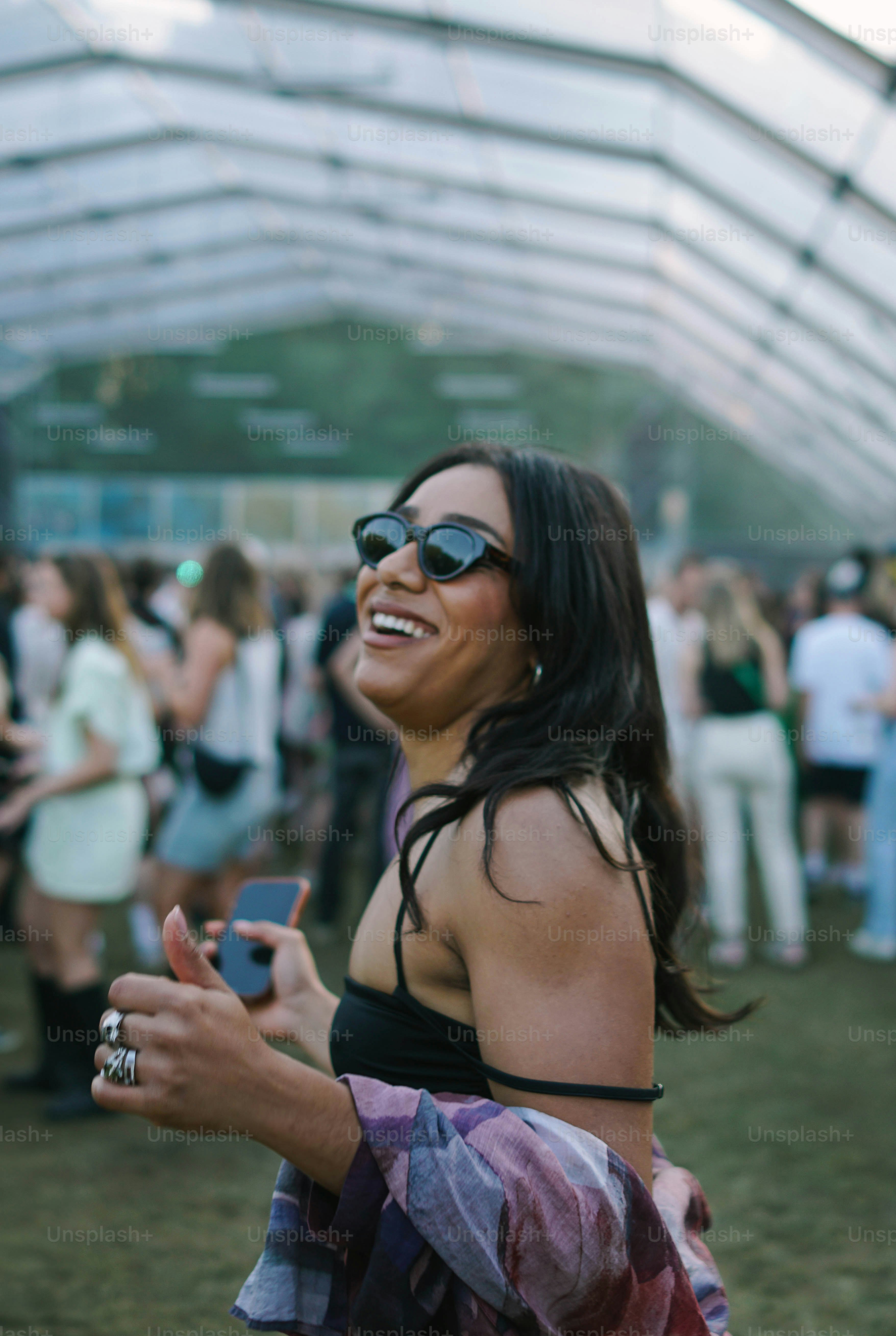 A woman in a black top and sunglasses standing in front of a group of people