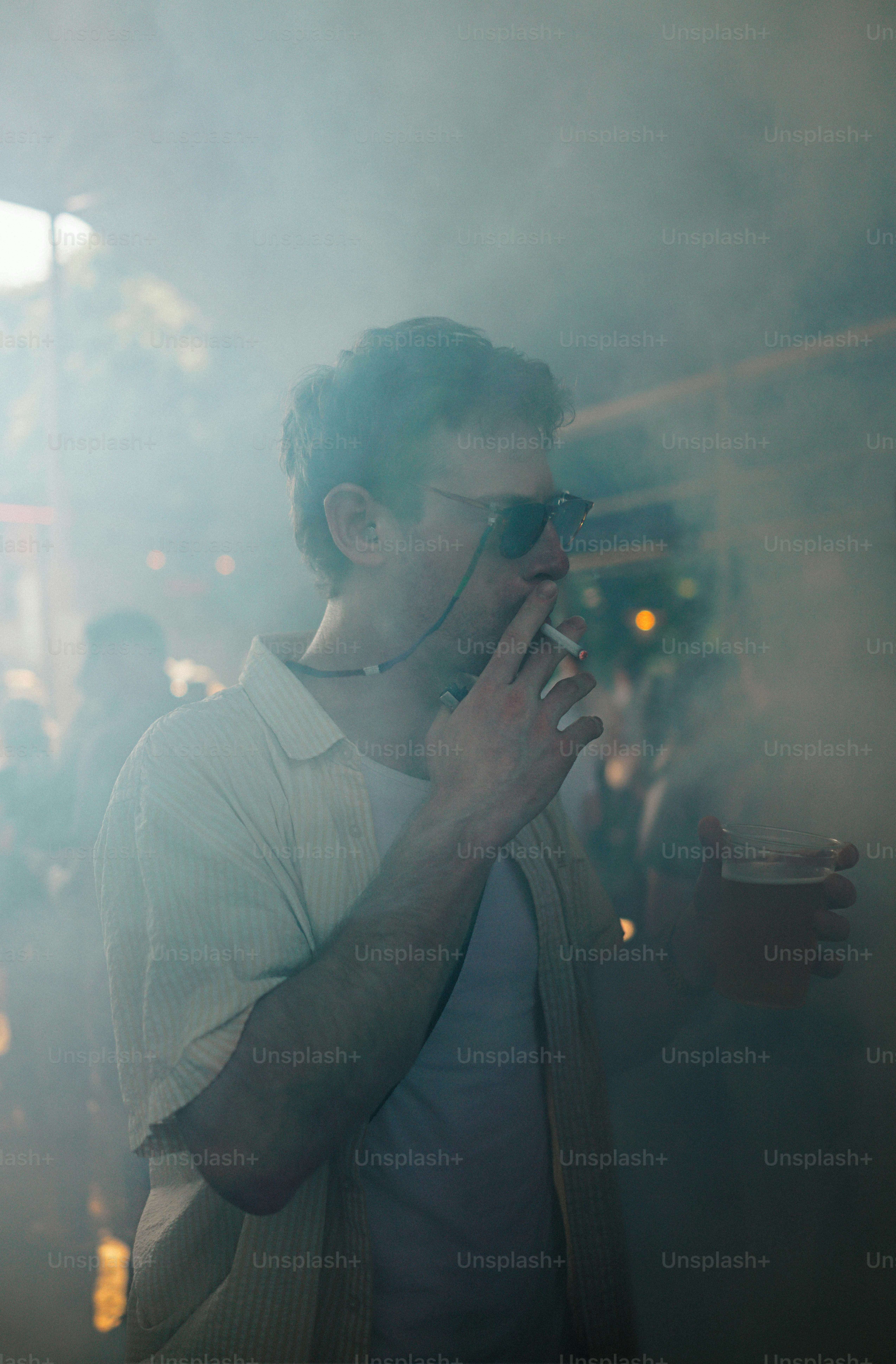 A man smoking a cigarette in a dark room