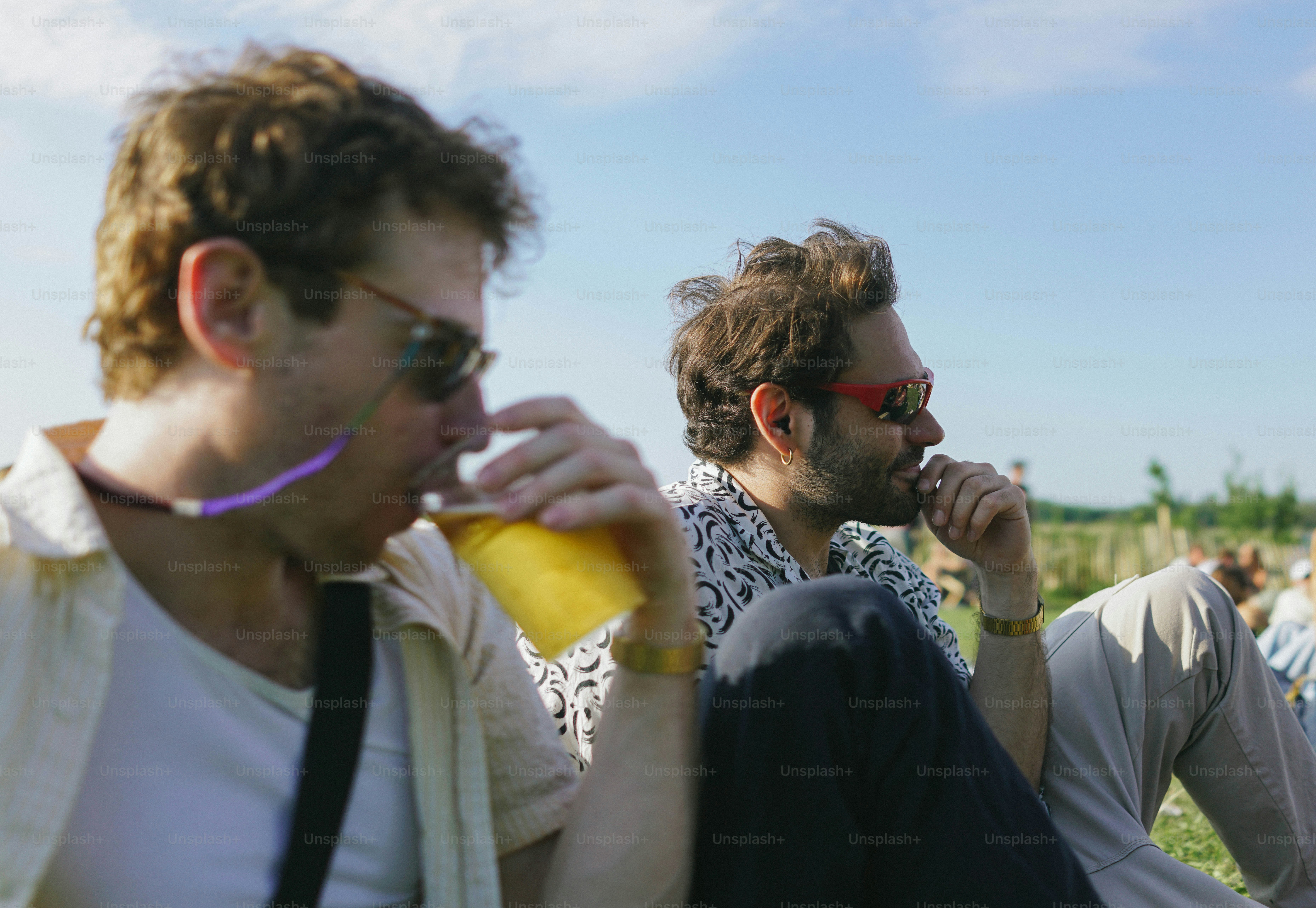 A group of men sitting on top of a grass covered field