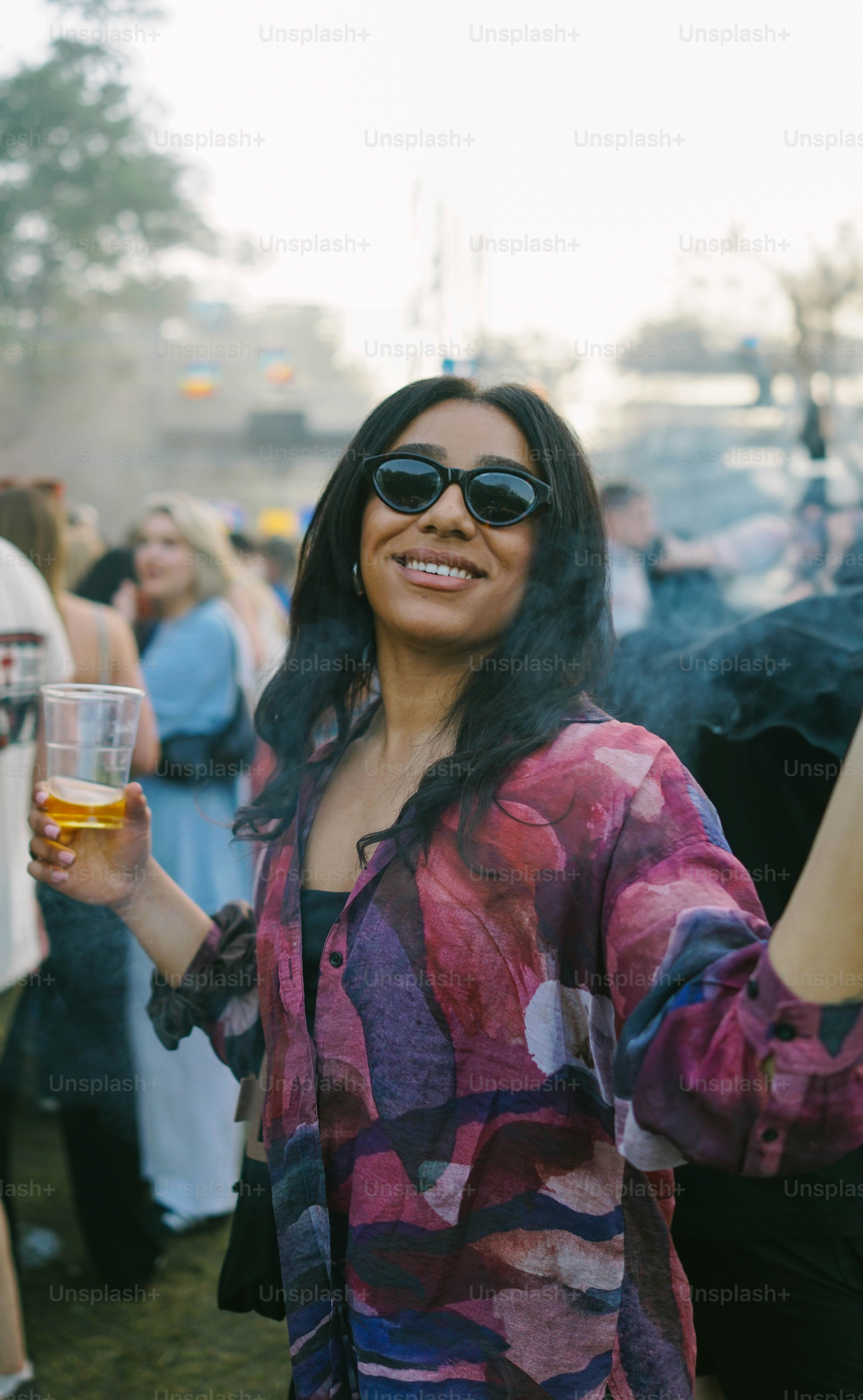 A group of people standing around each other holding glasses of beer ...