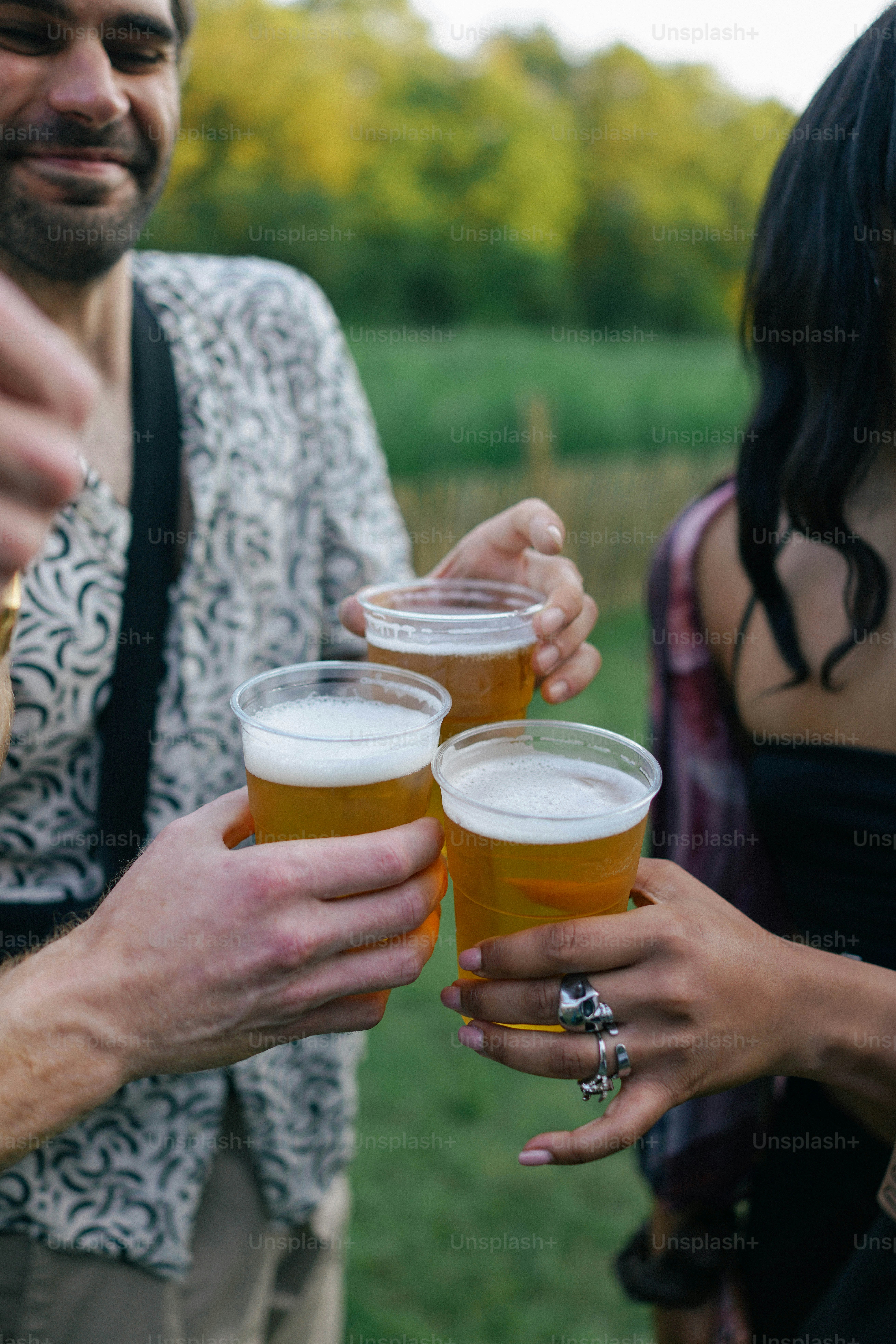 Un grupo de personas de pie una al lado de la otra sosteniendo cervezas