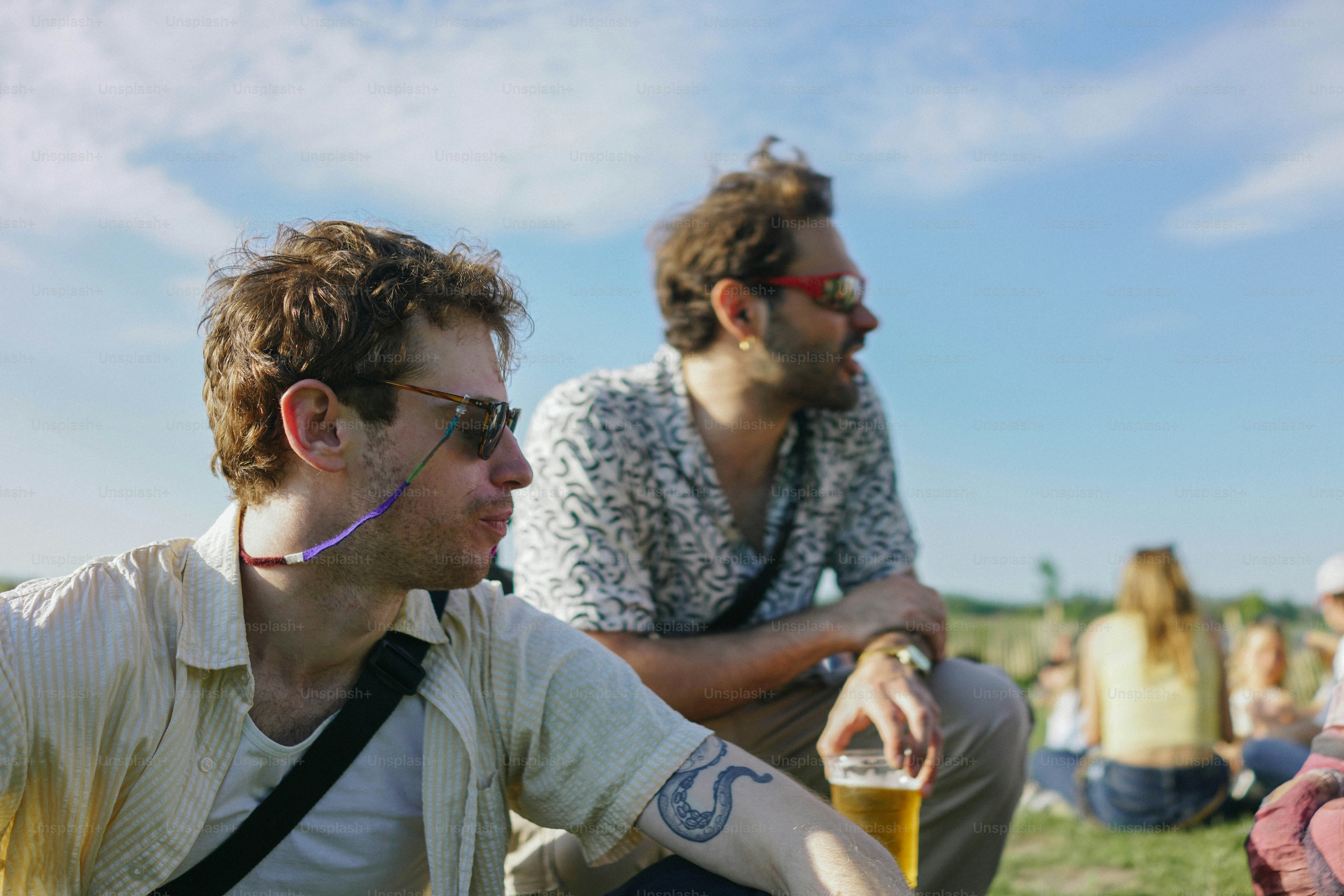 A group of people sitting on top of a grass covered field