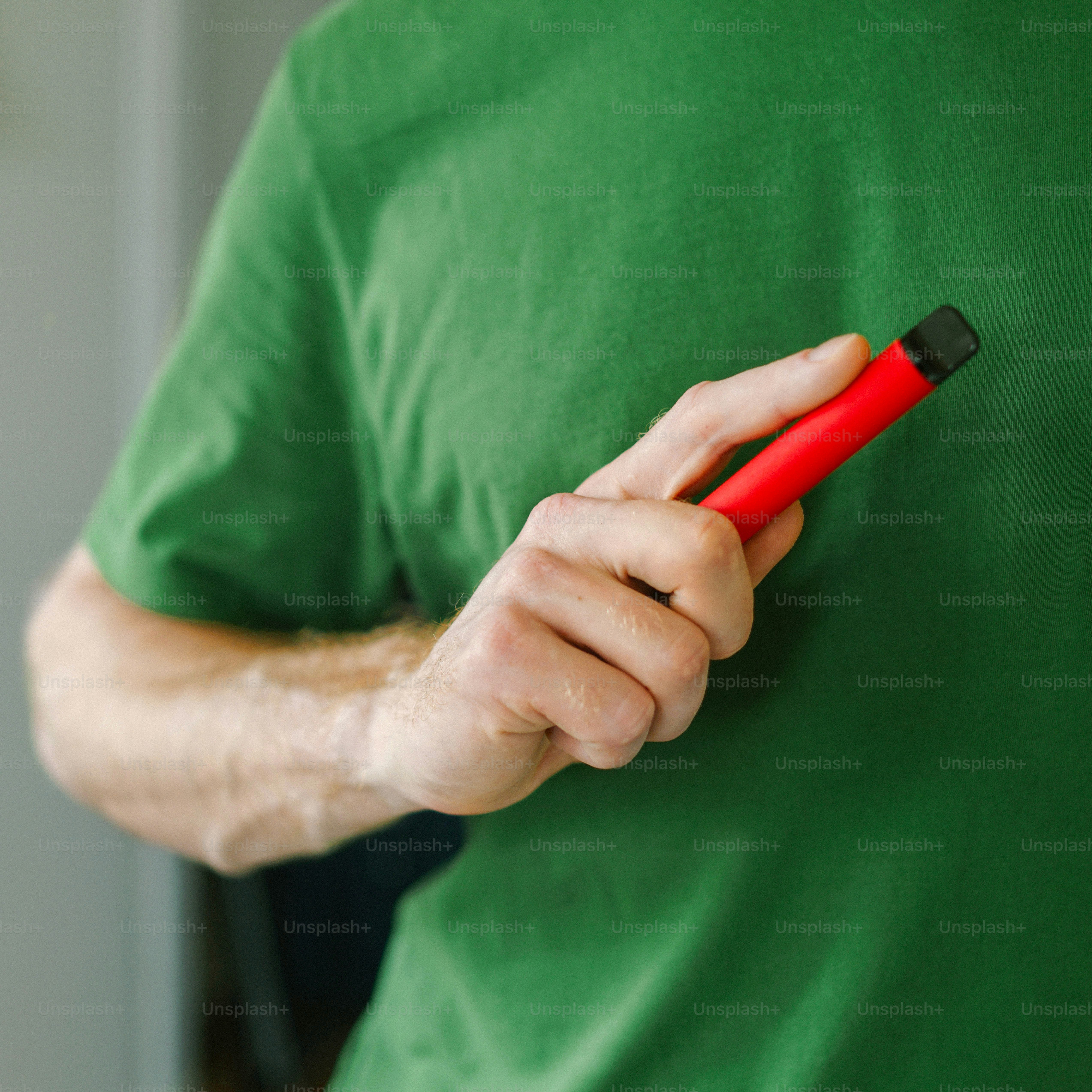 A man in a green shirt holding a red object