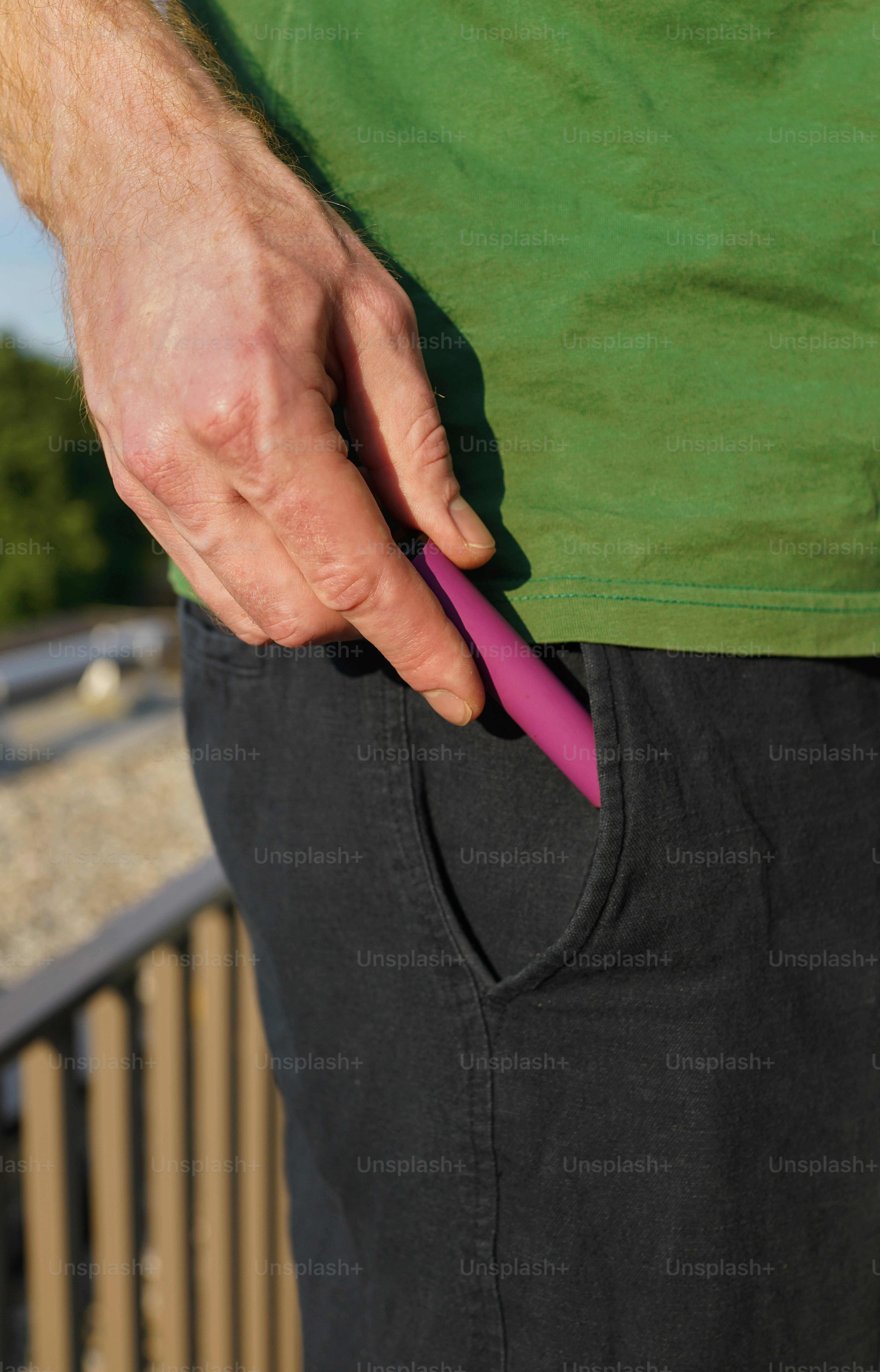 A man holding a pink object in his pocket
