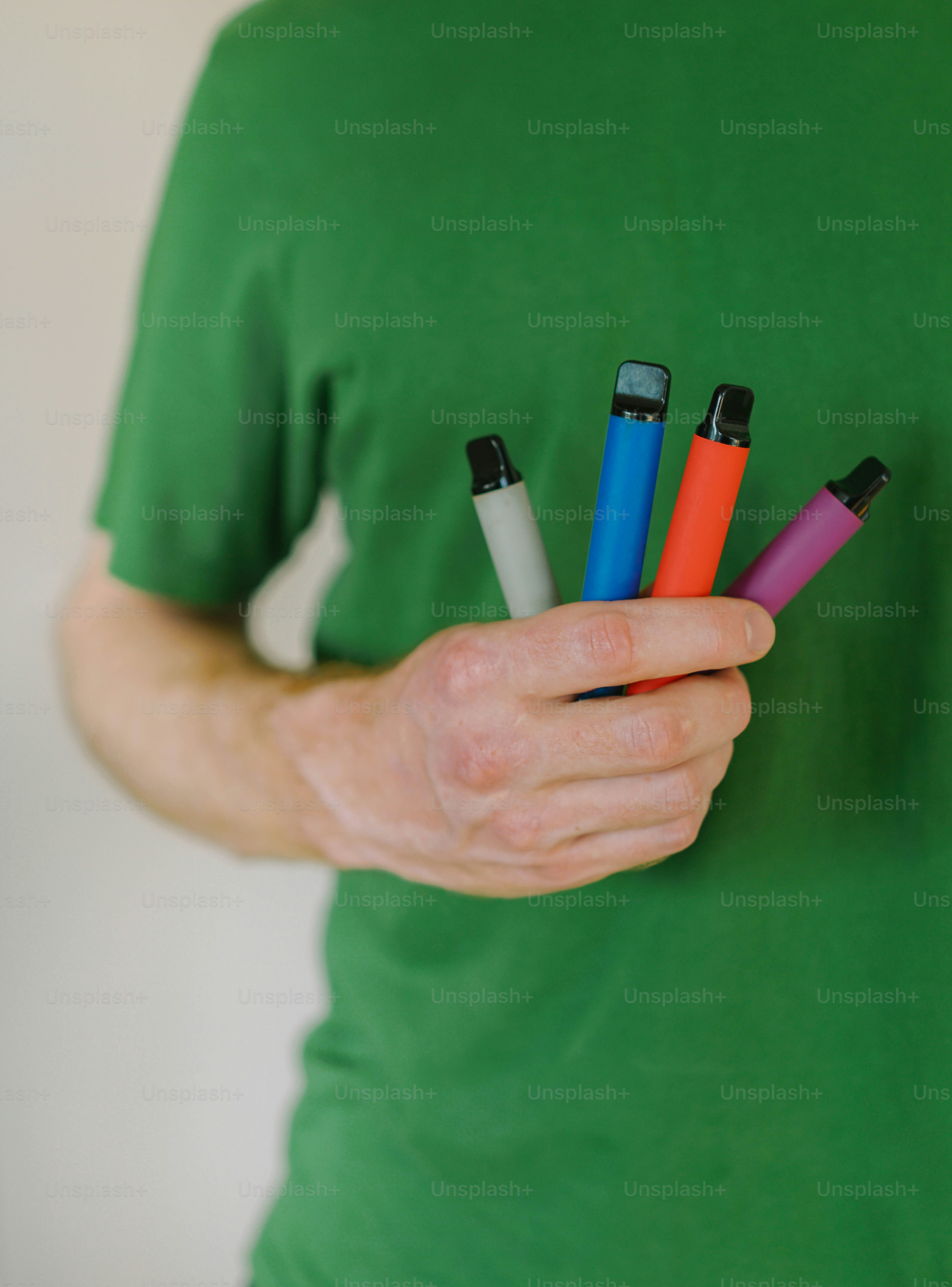 A man holding four electronic devices in his hand