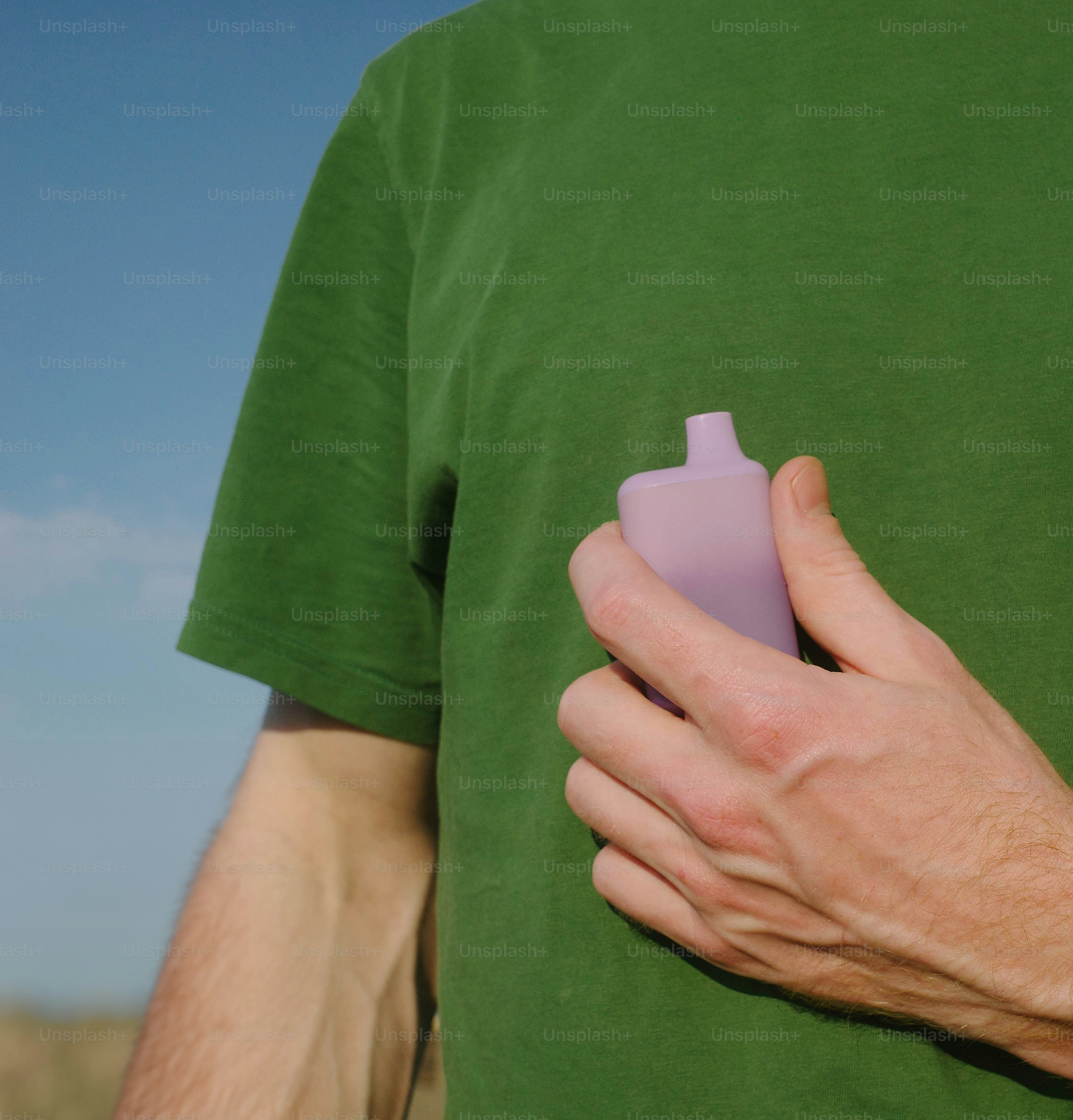 A man in a green shirt holding a pink object