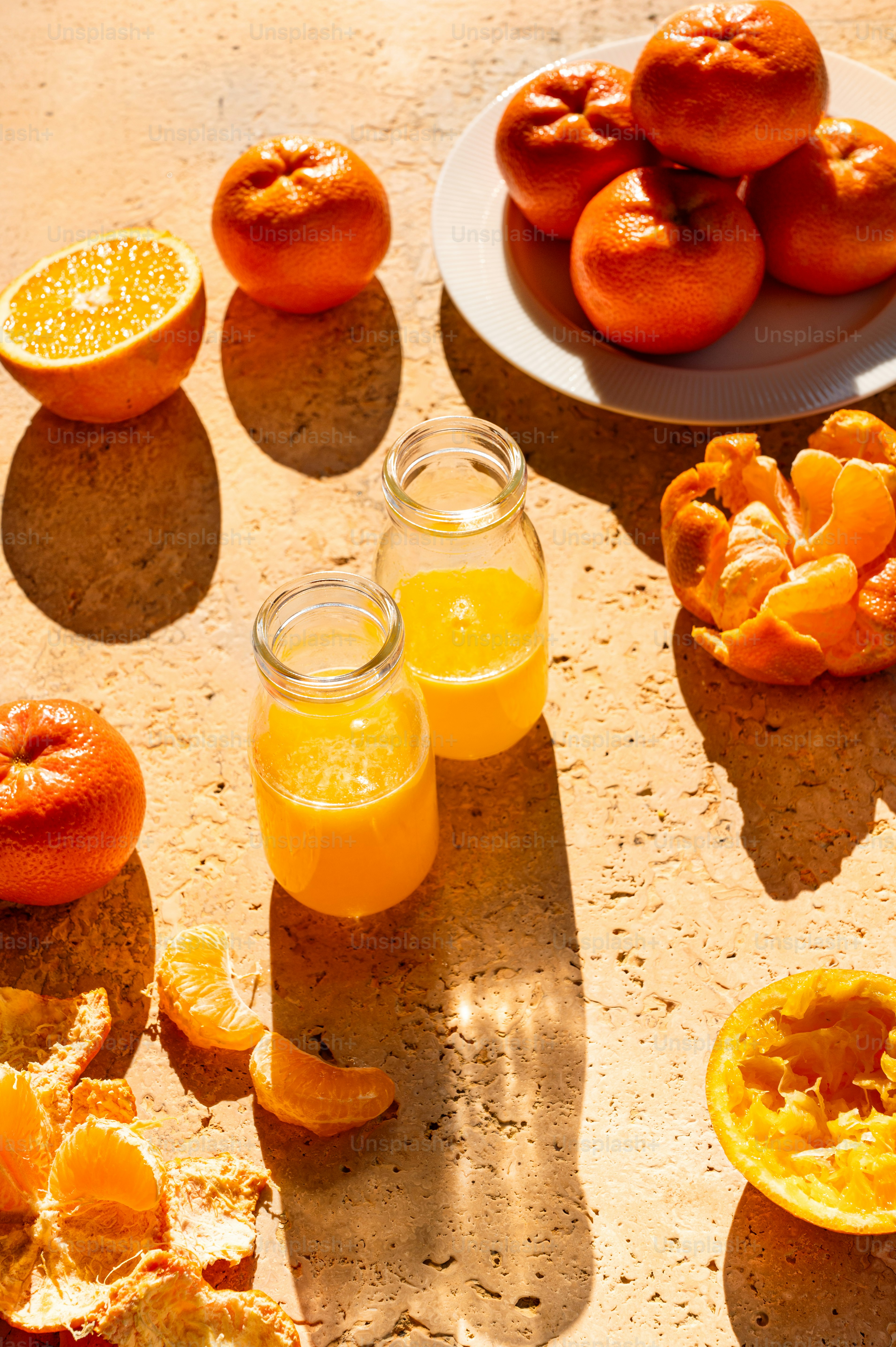 Un tavolo sormontato da arance e muffin accanto a un piatto di arancia