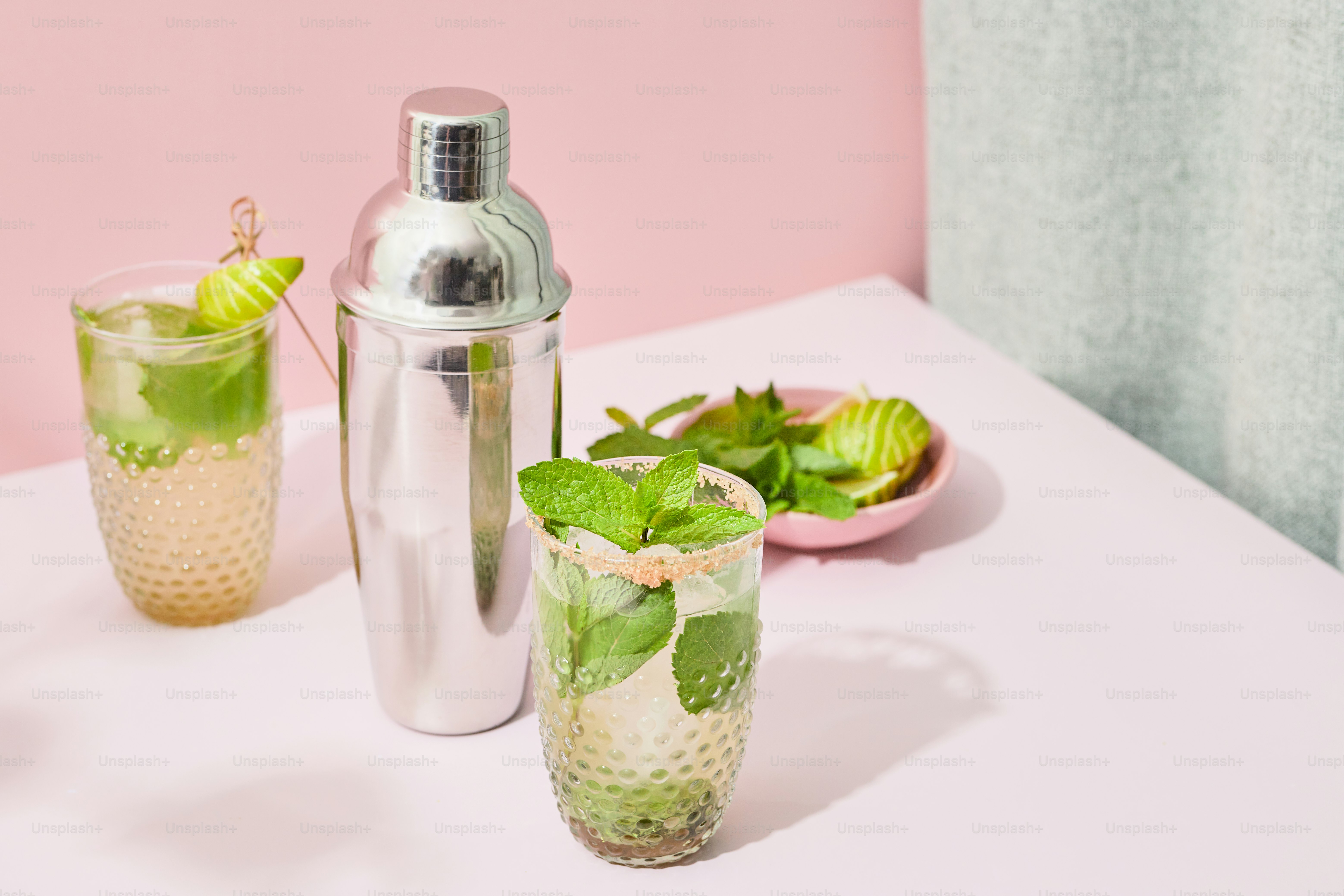 A white table topped with two glasses filled with drinks