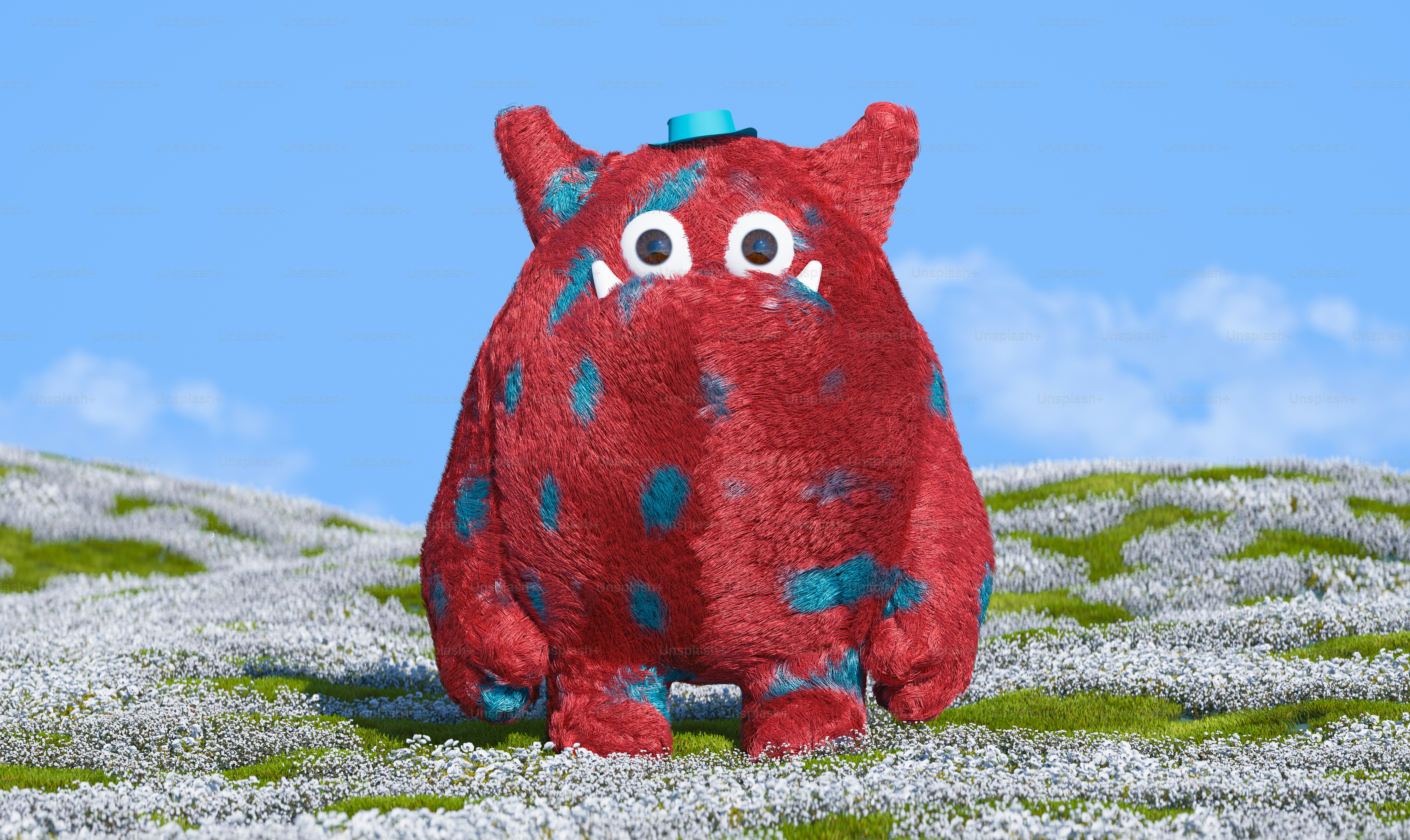 Ein rotes Kuscheltier sitzt auf einem grasbewachsenen Hügel