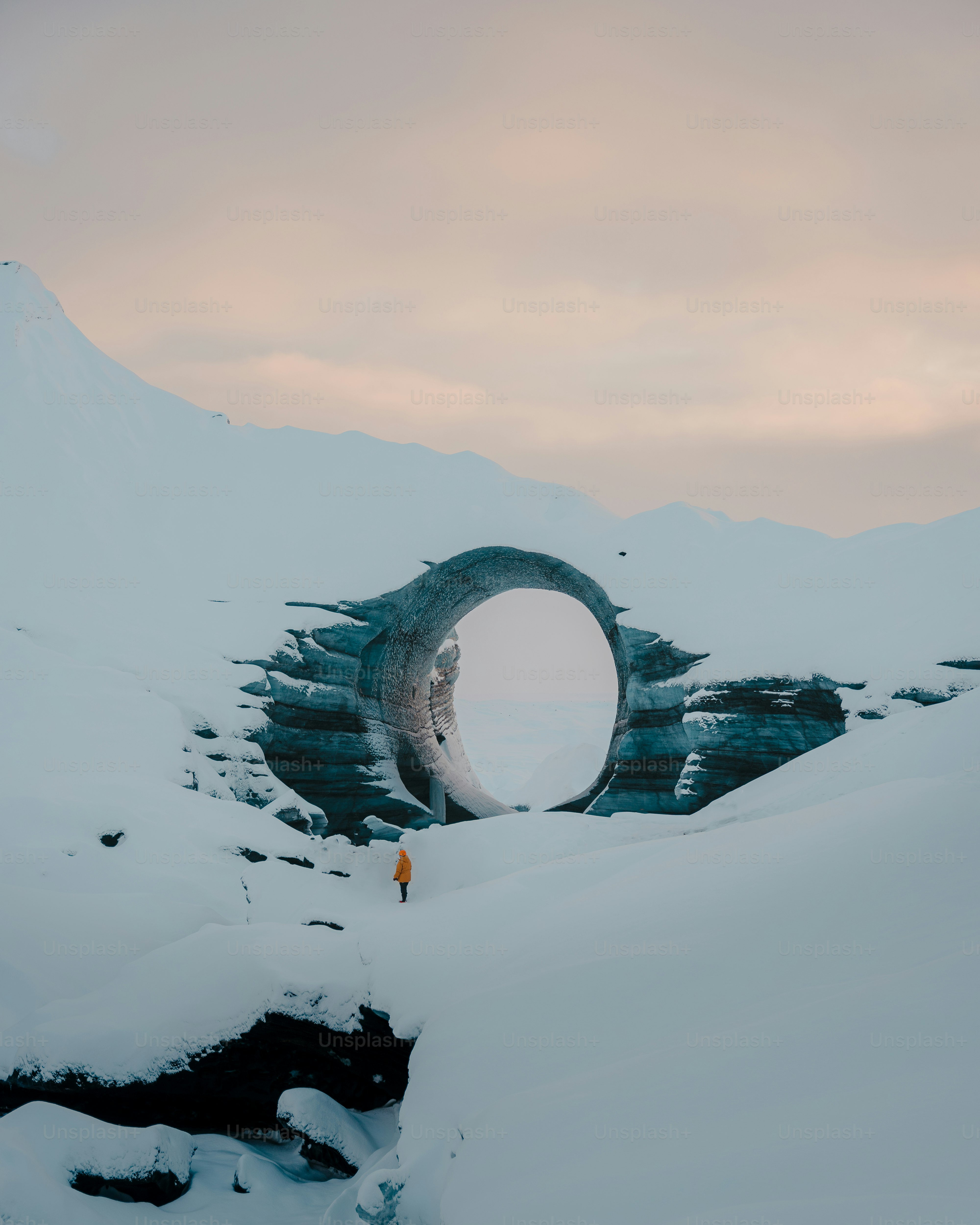 A man standing in the middle of a snow covered mountain