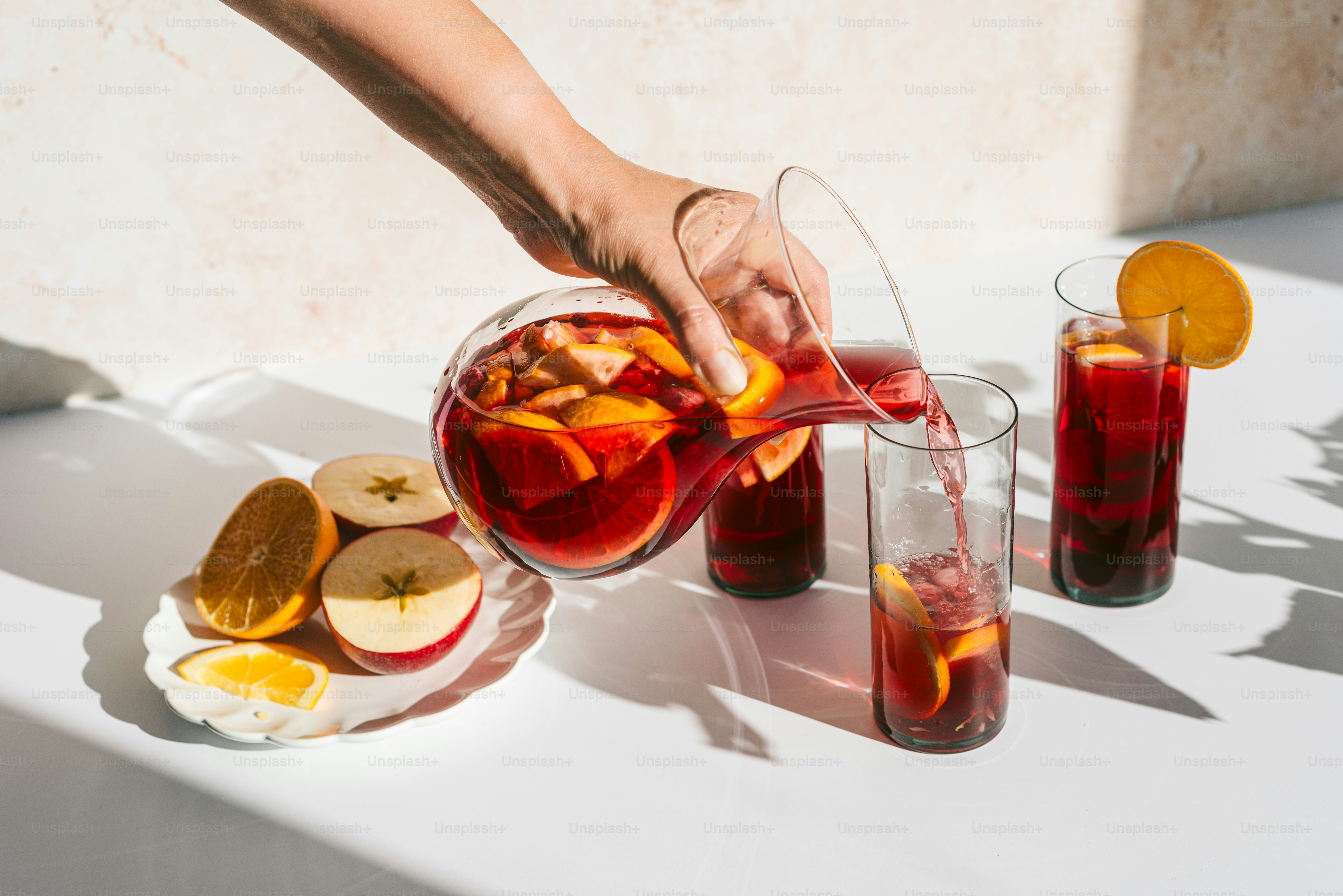 A person pouring a pitcher of liquid into a glass