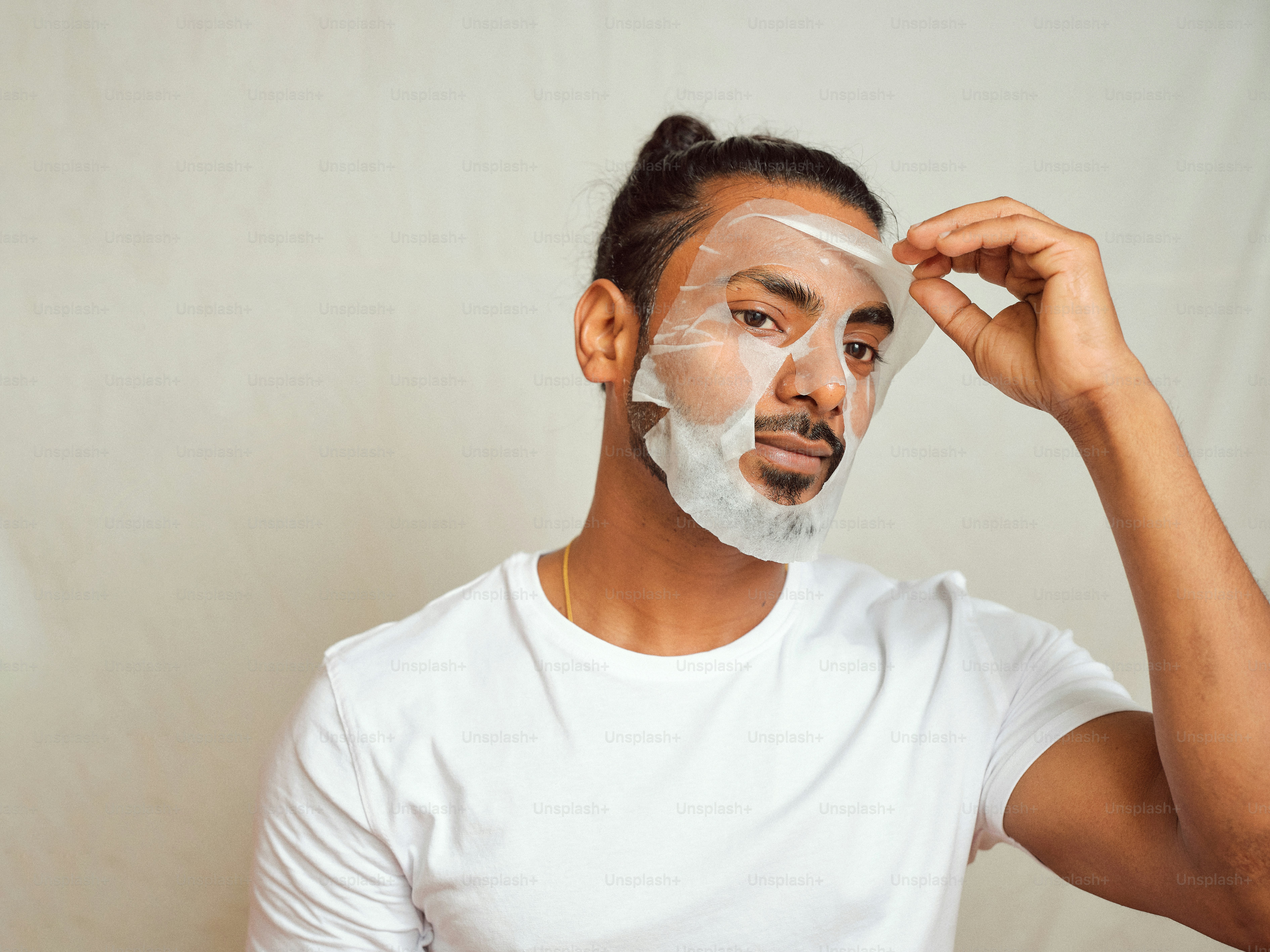 Un homme se rase le visage avec un masque facial