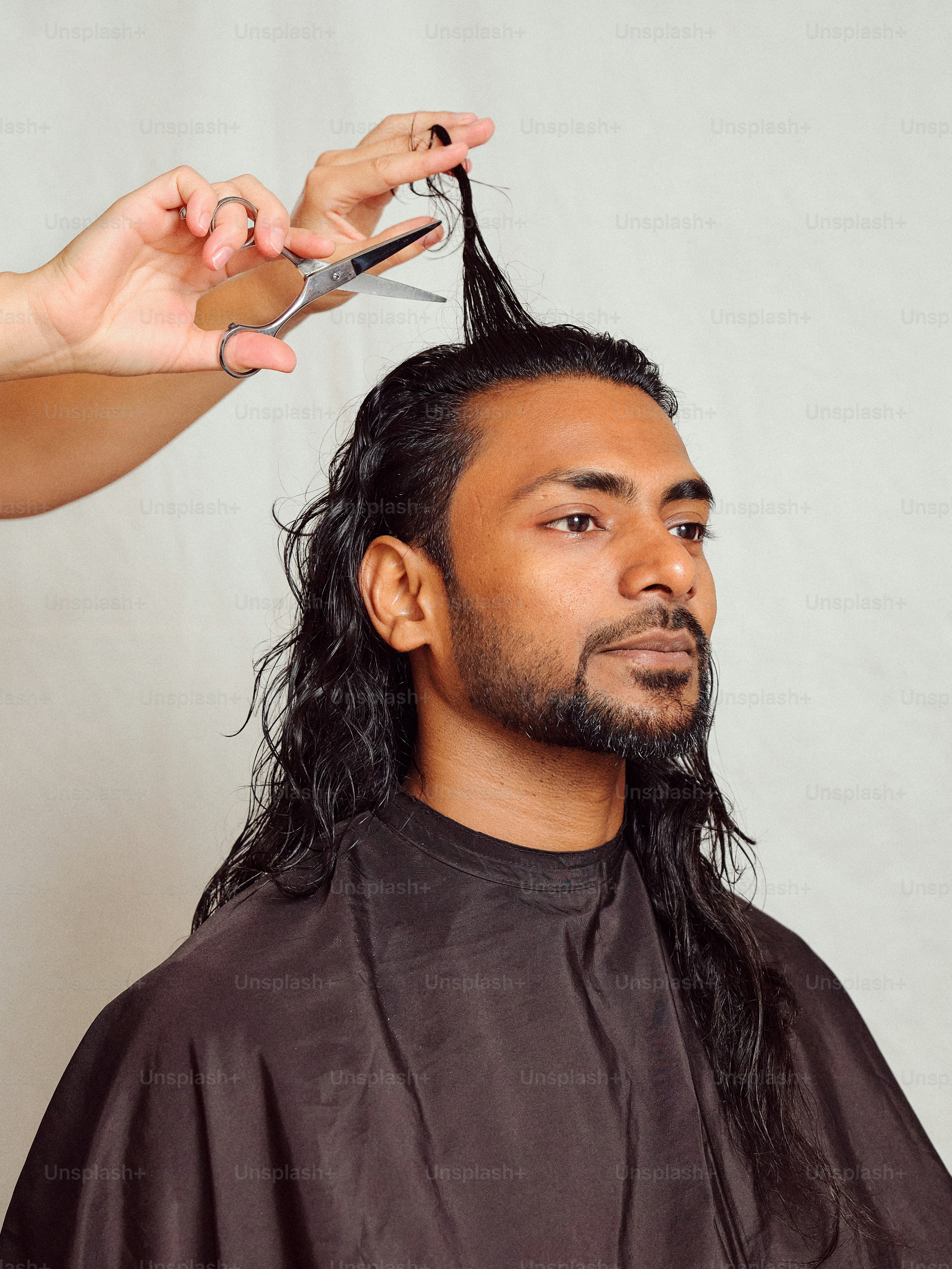 A man getting his hair cut by a woman