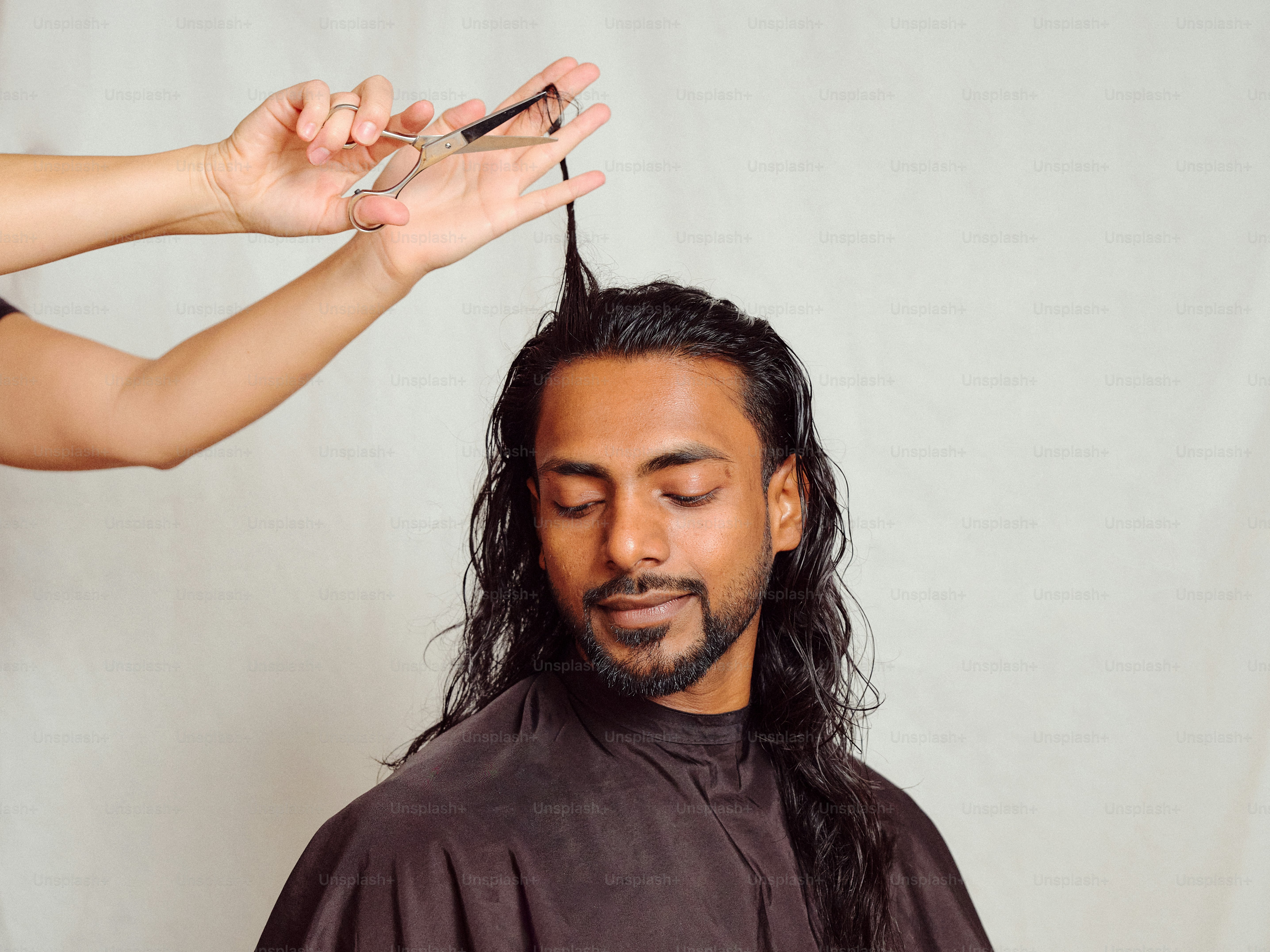 Un uomo che si fa tagliare i capelli da una donna