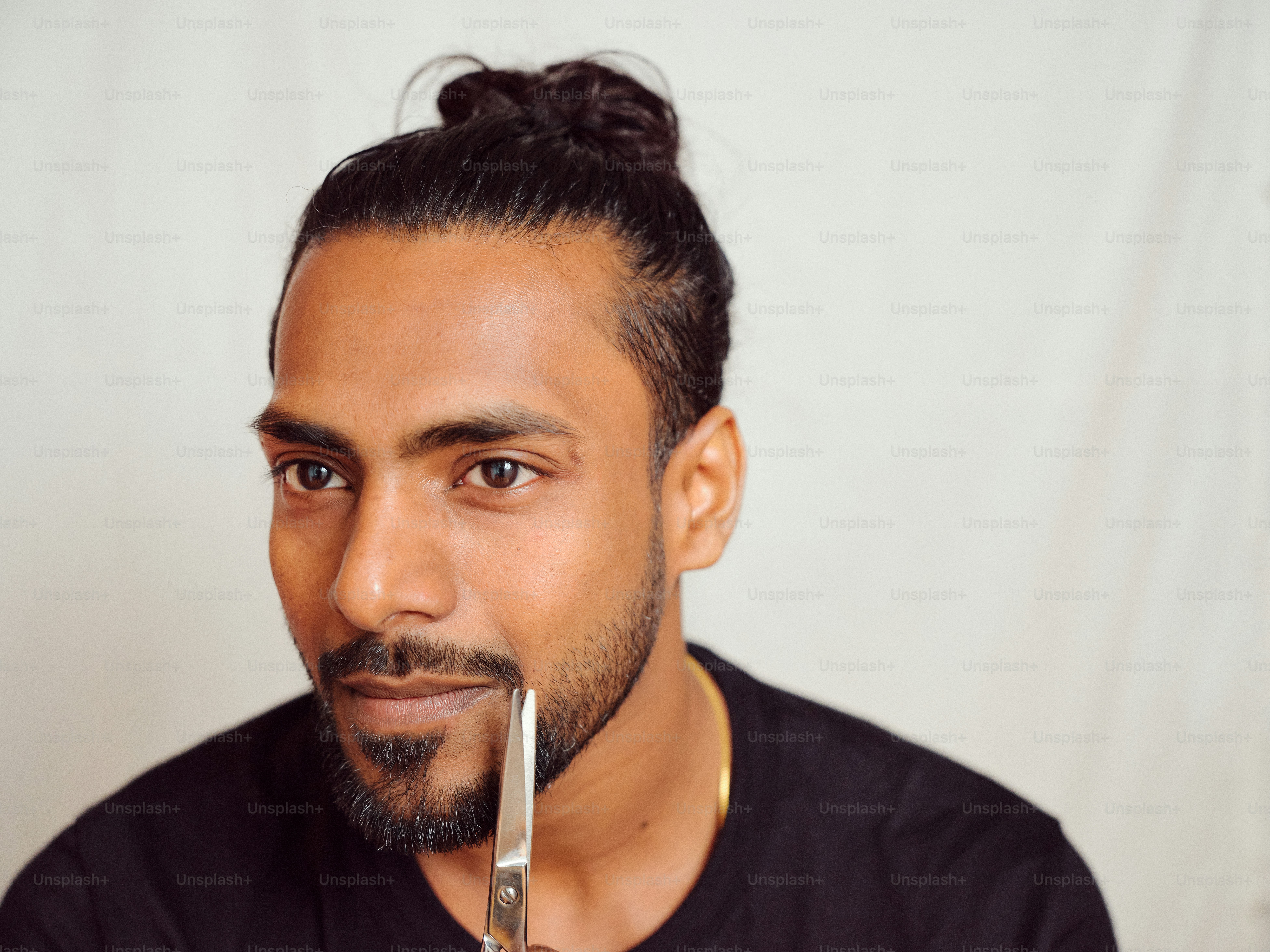 A man holding a pair of scissors in his mouth