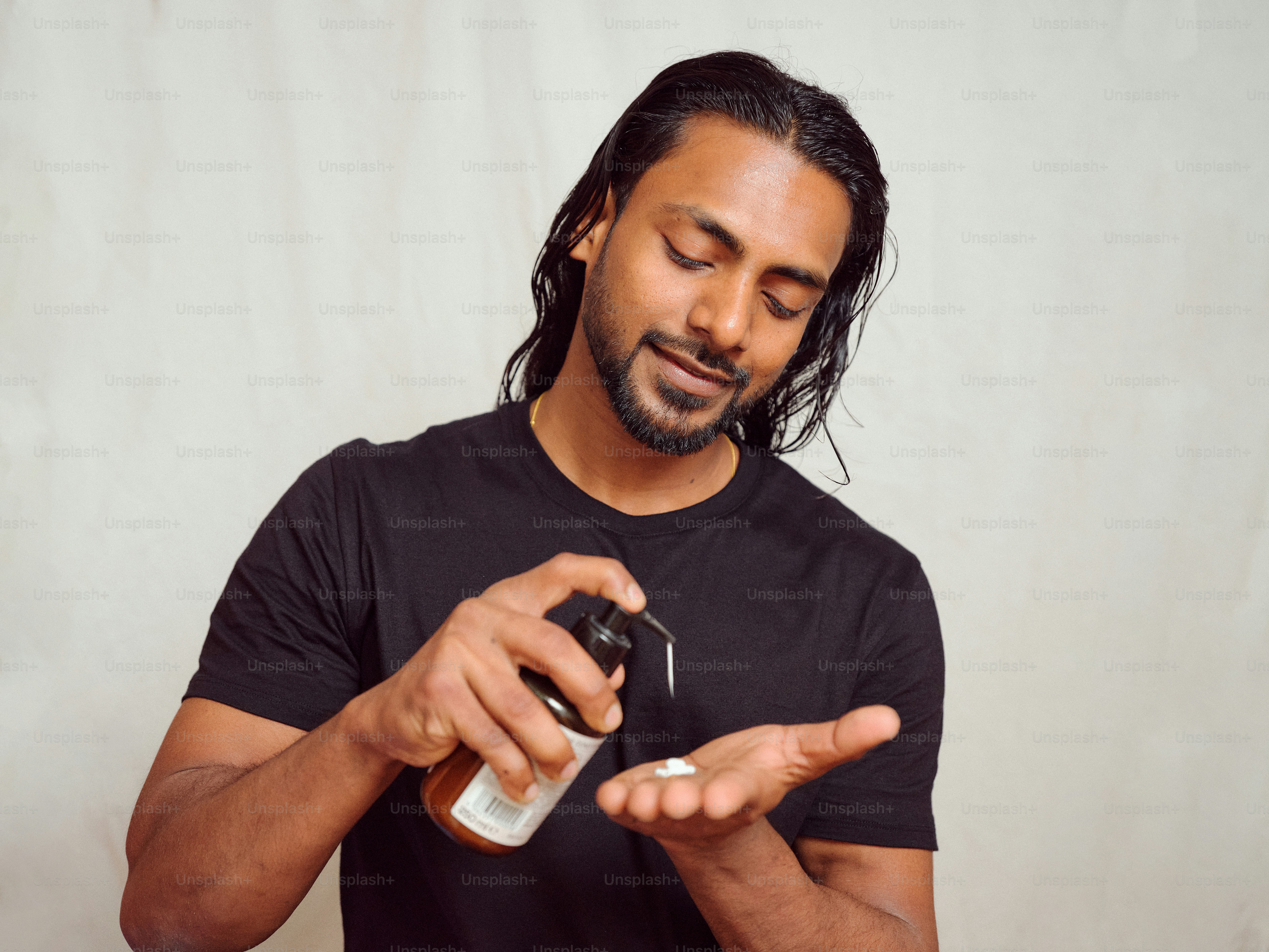 Un uomo che tiene una bottiglia e un cellulare