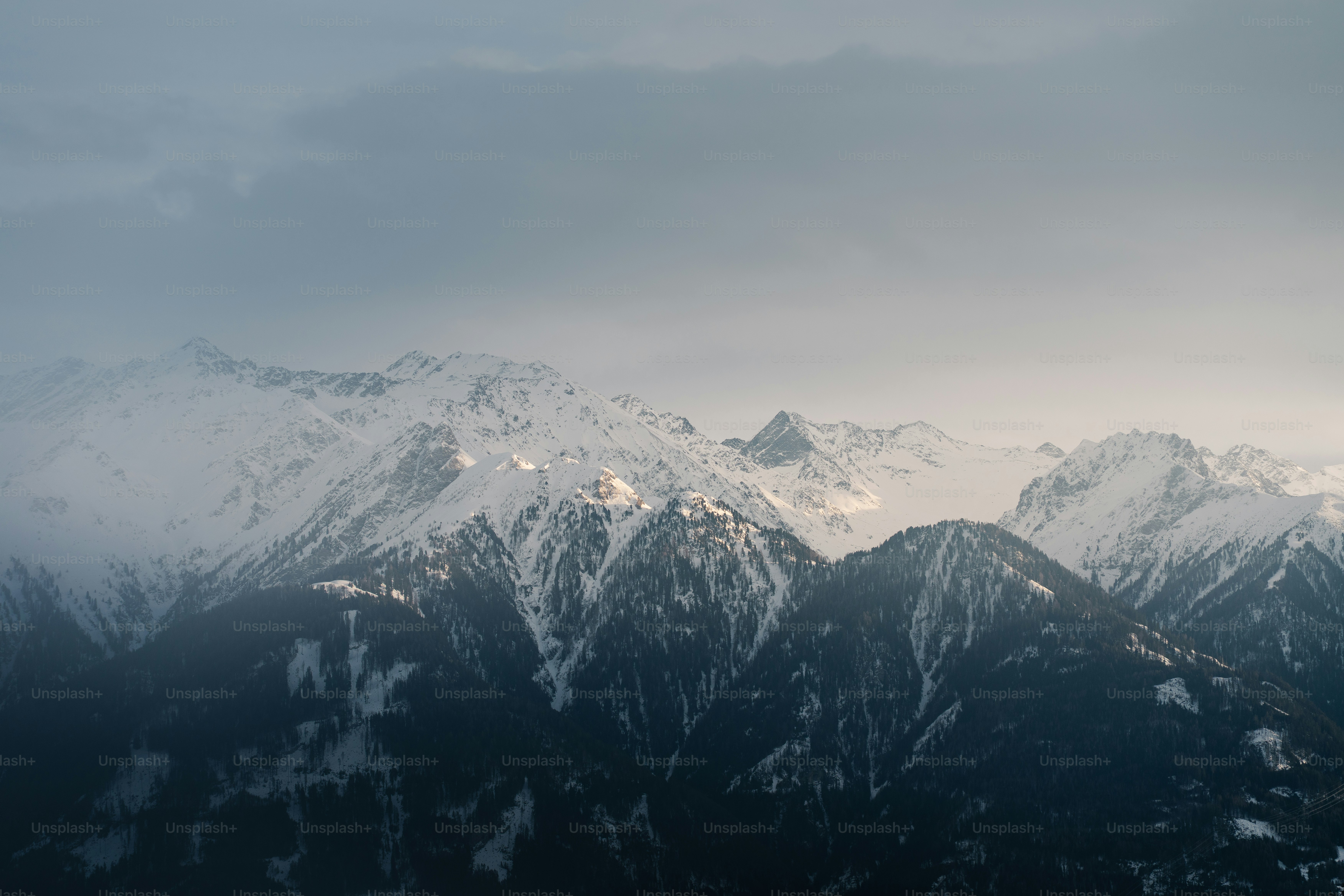 Una catena montuosa innevata sotto un cielo nuvoloso