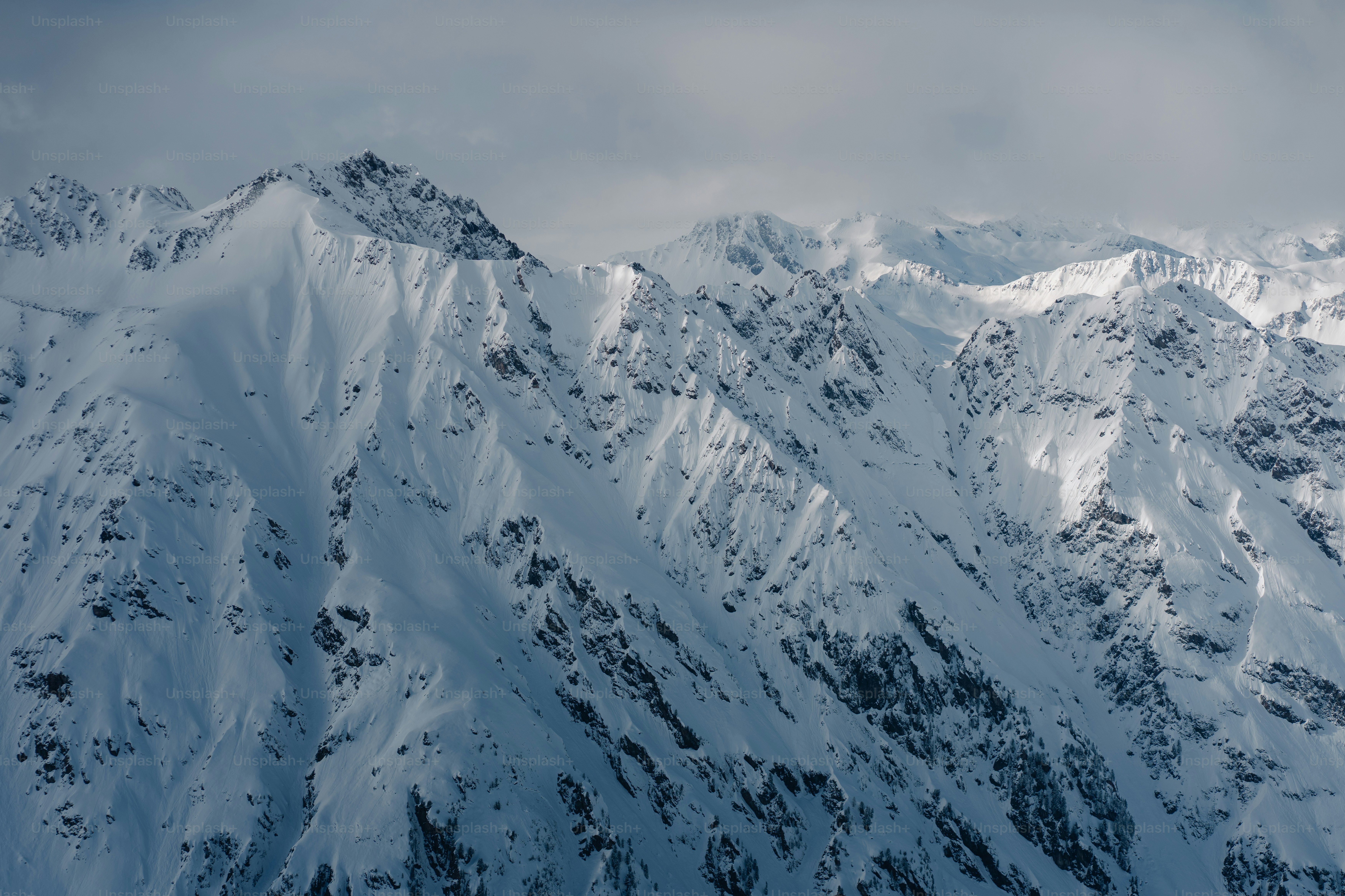 Una montagna coperta di neve sotto un cielo nuvoloso