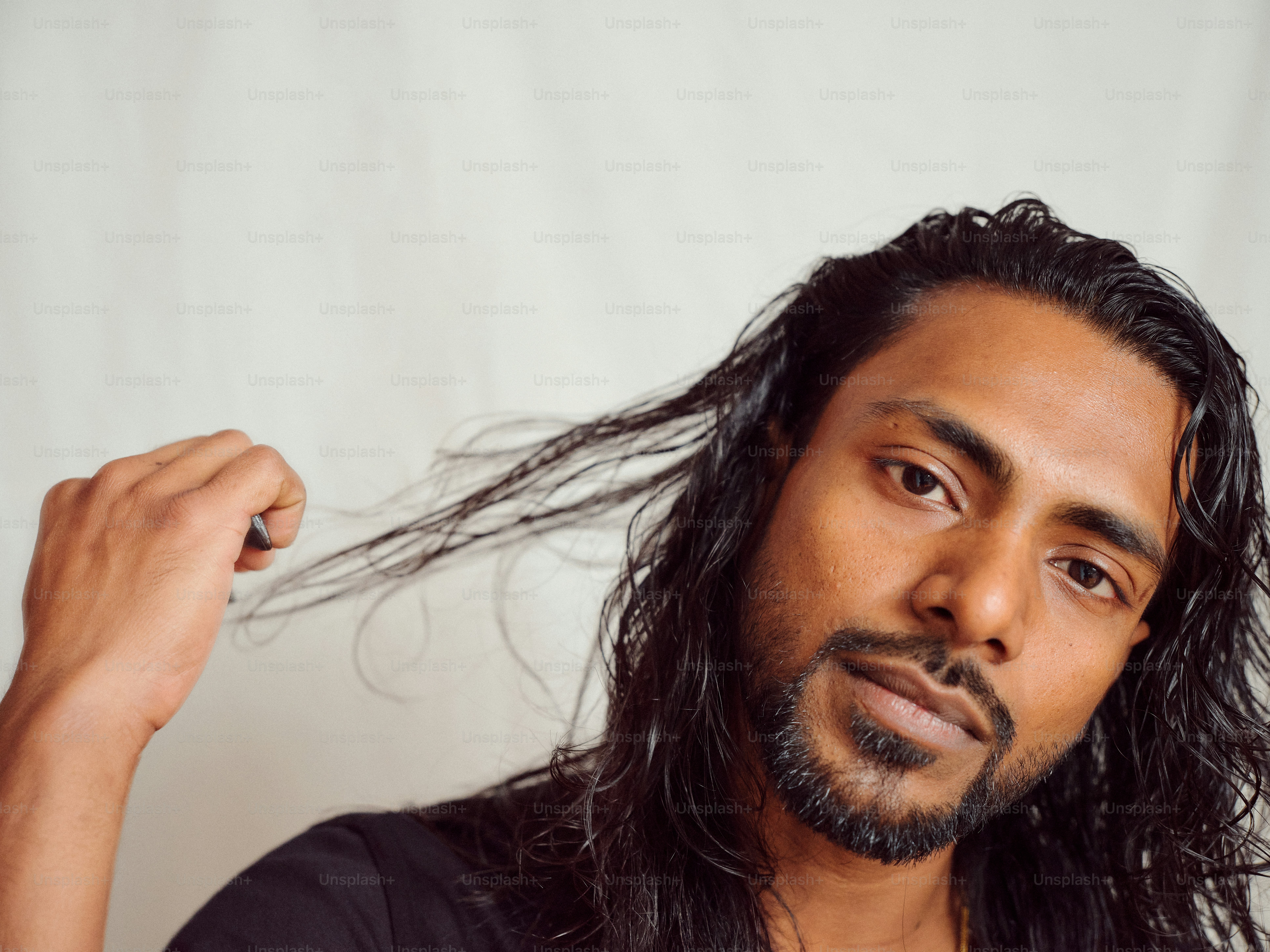 A man with long hair and a black shirt