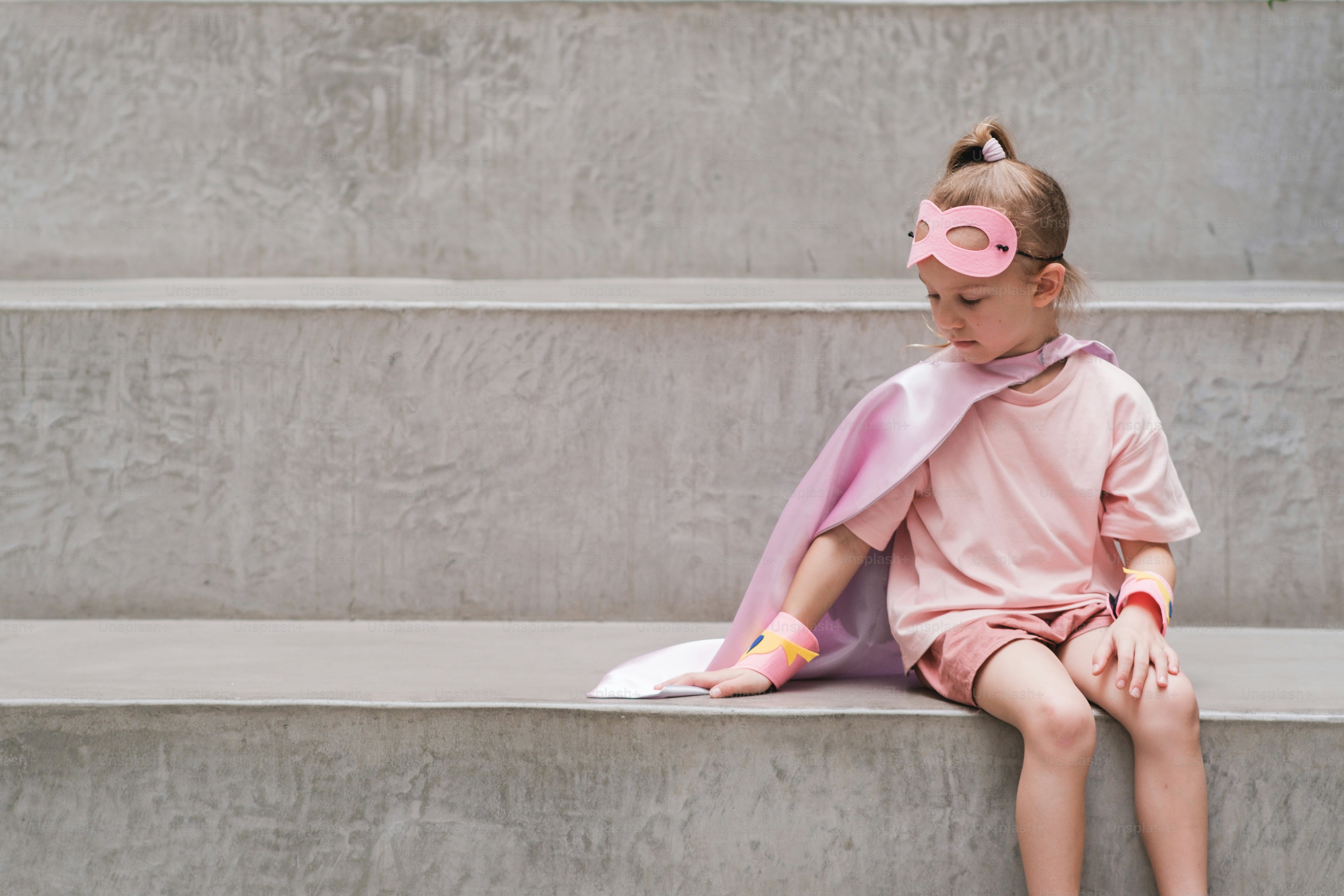 A little girl sitting on a set of stairs