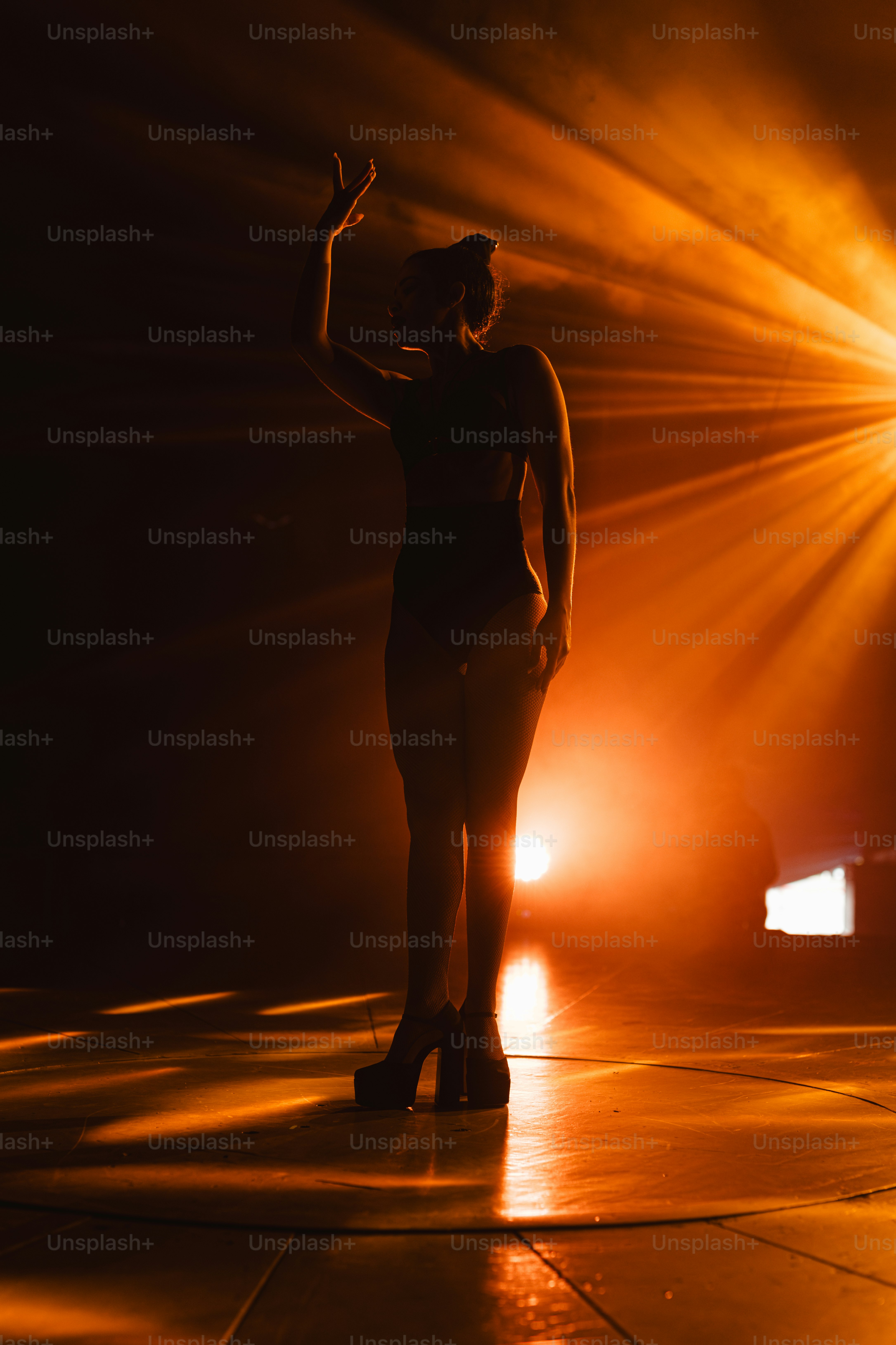 A woman standing on a stage in front of a spotlight