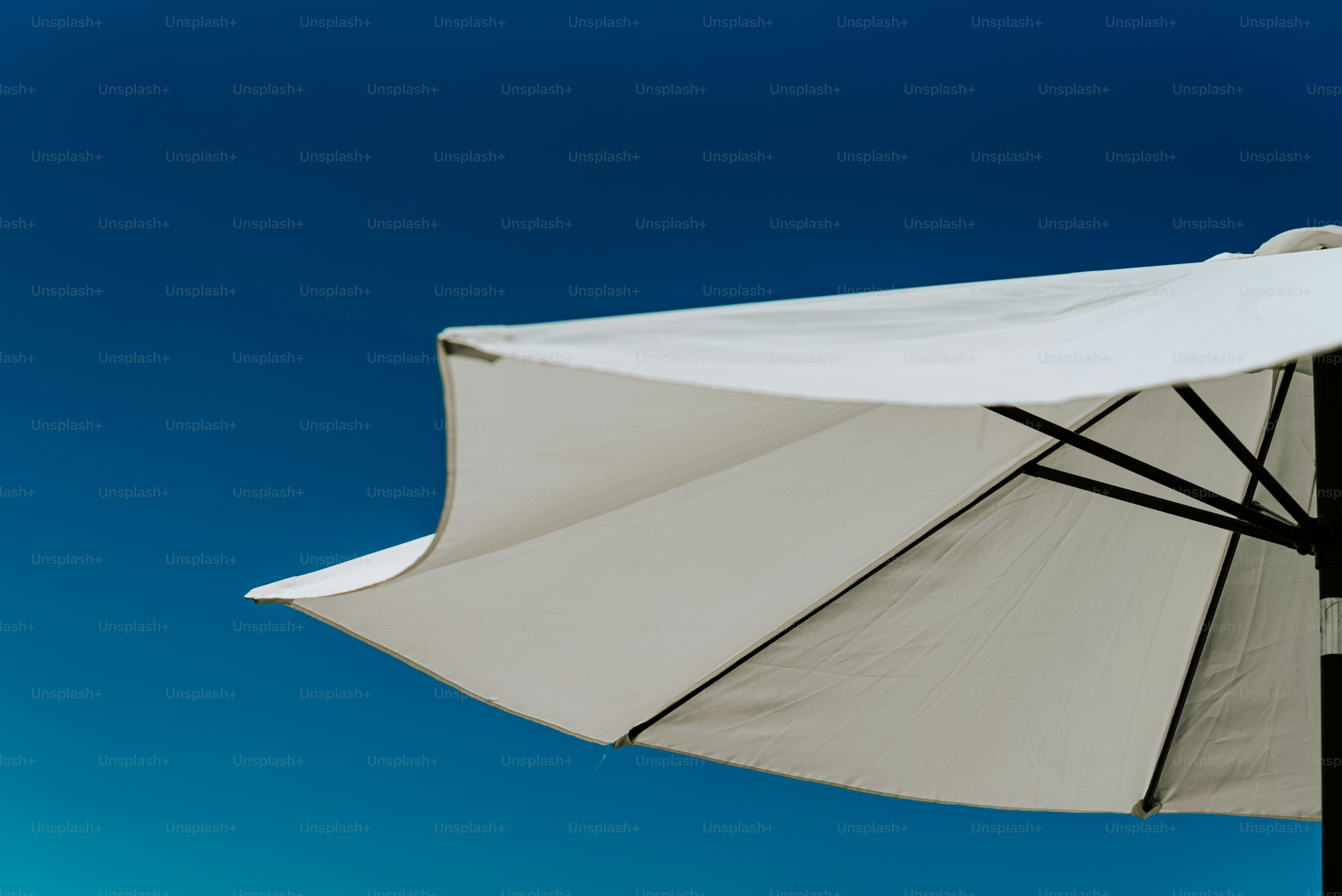 A white umbrella with a blue sky in the background