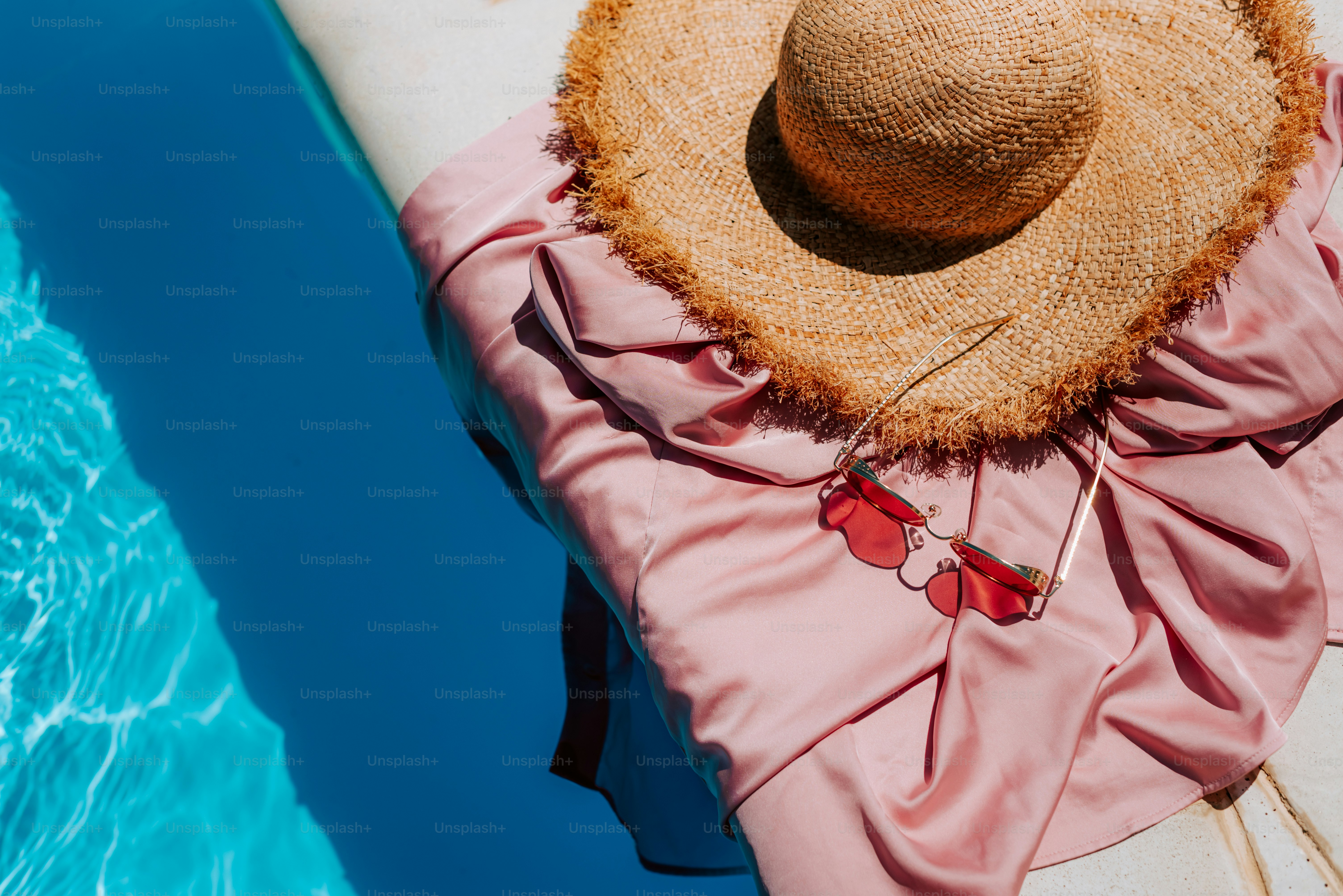 Una donna con un vestito rosa e un cappello di paglia seduta su una barca