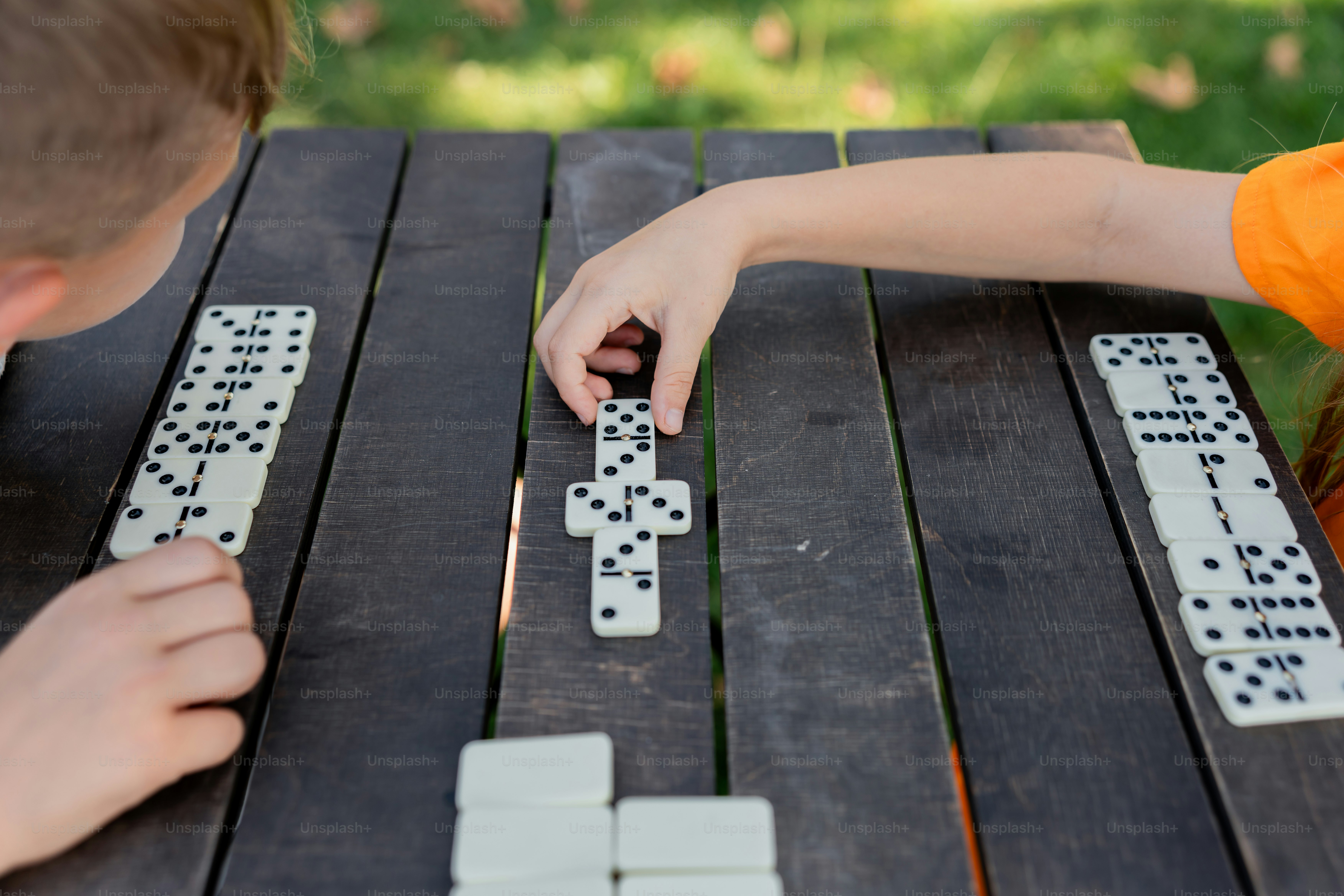 Un par de niños jugando con dominó en una mesa foto – Imagen de Juegos ...