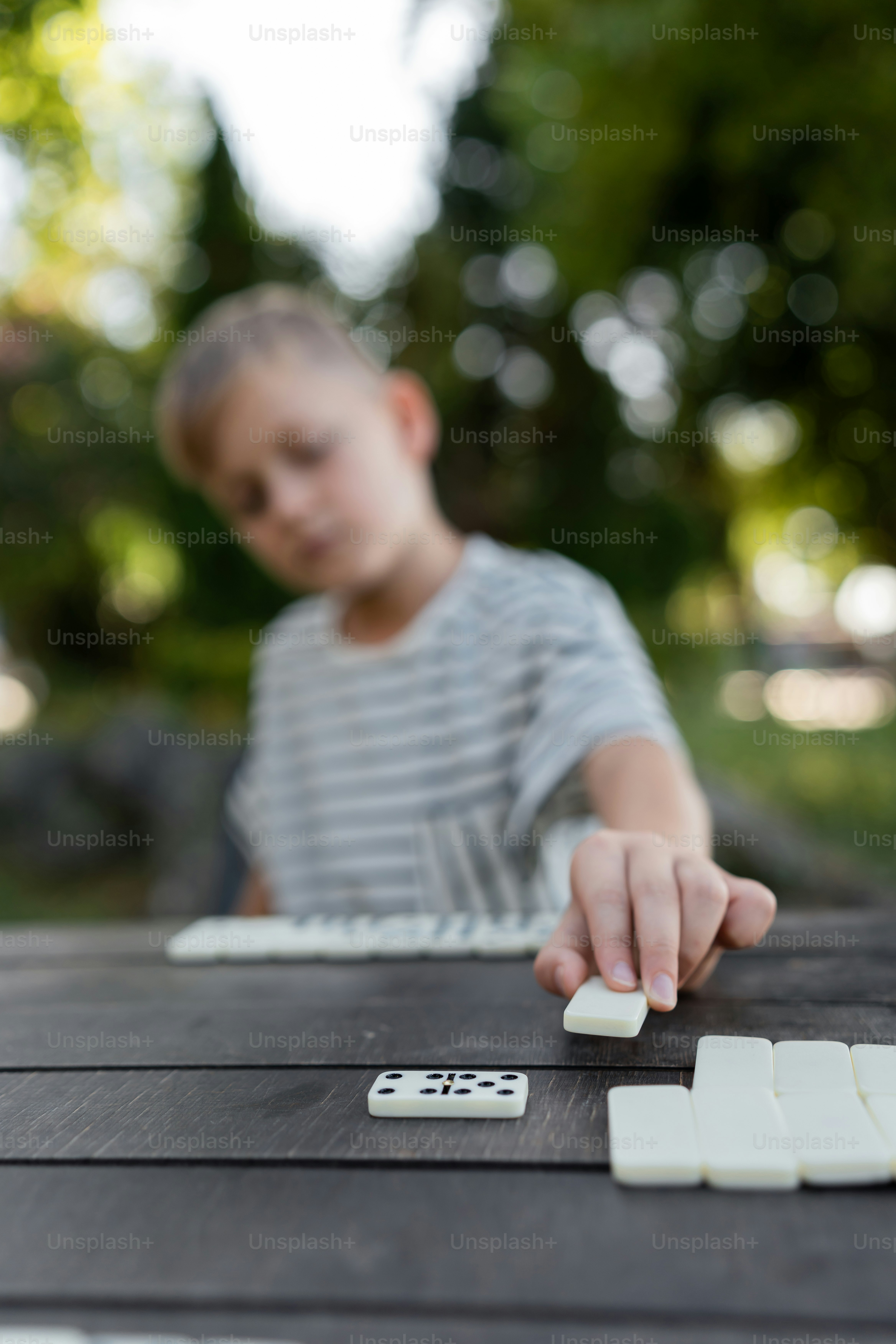 A young boy playing a game of dominos