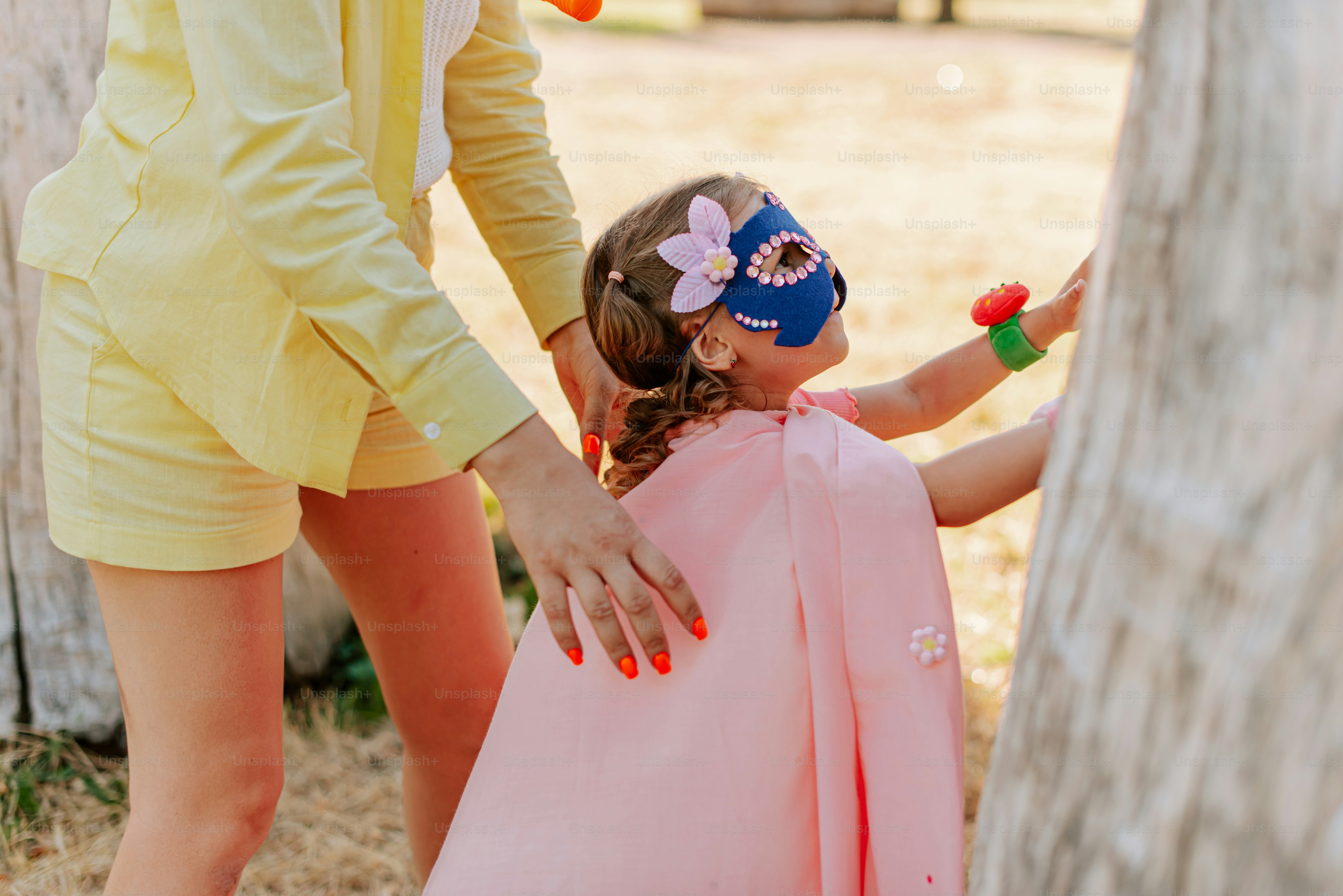 A little girl in a pink dress and a woman in a yellow suit