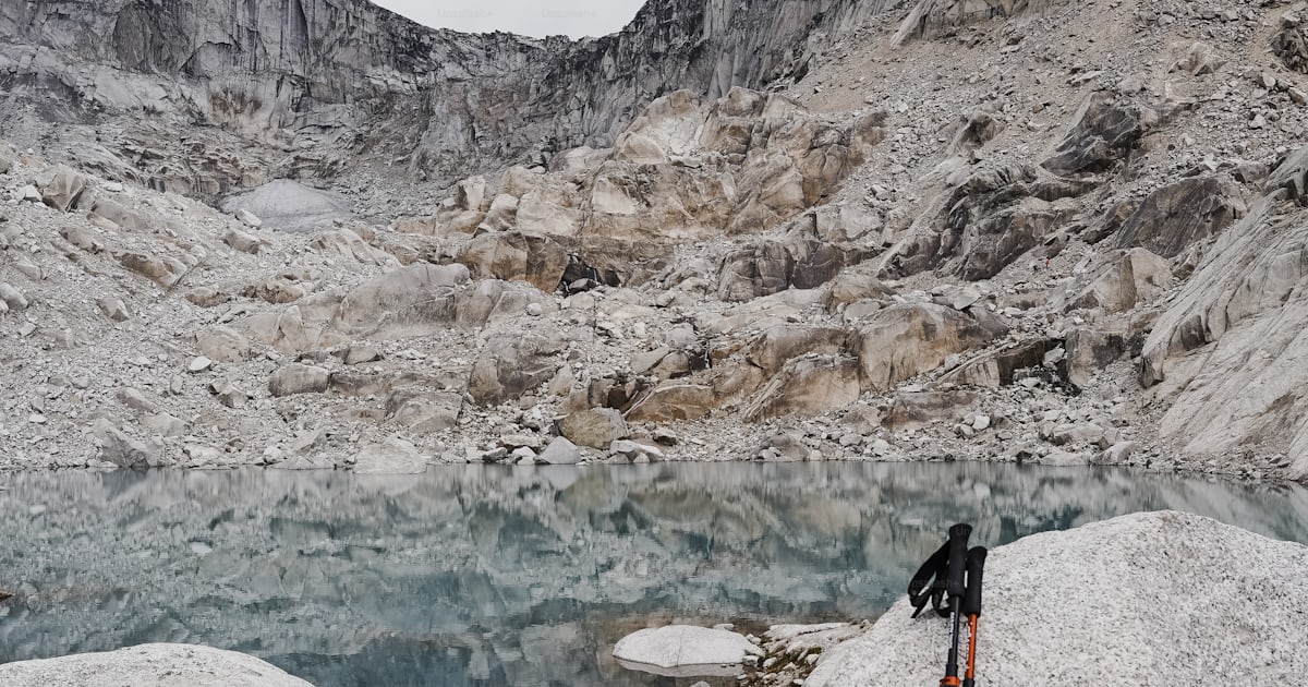 A pair of skis sitting on top of a large rock photo – Canada Image on ...