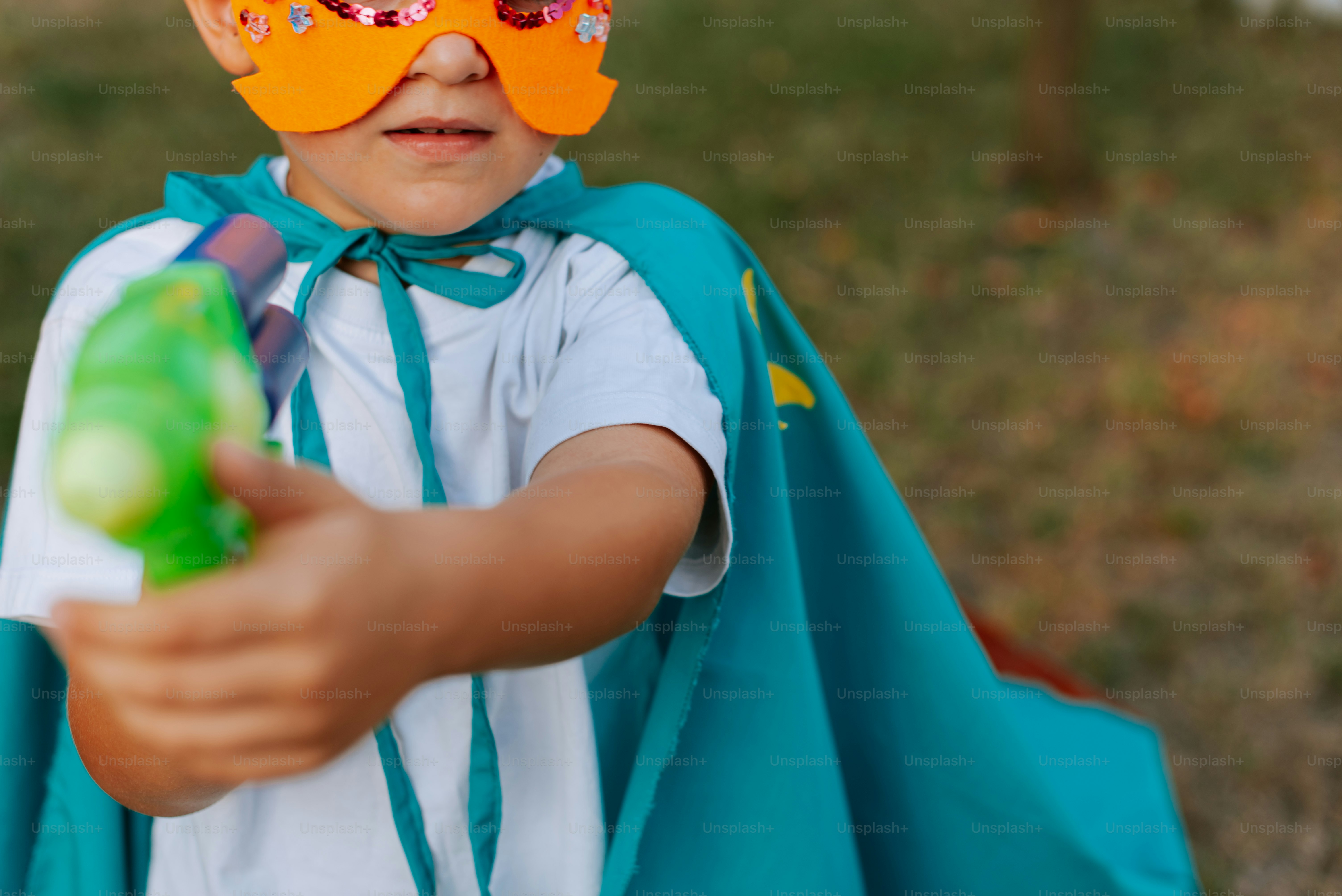 A little boy wearing a mask and holding a toy