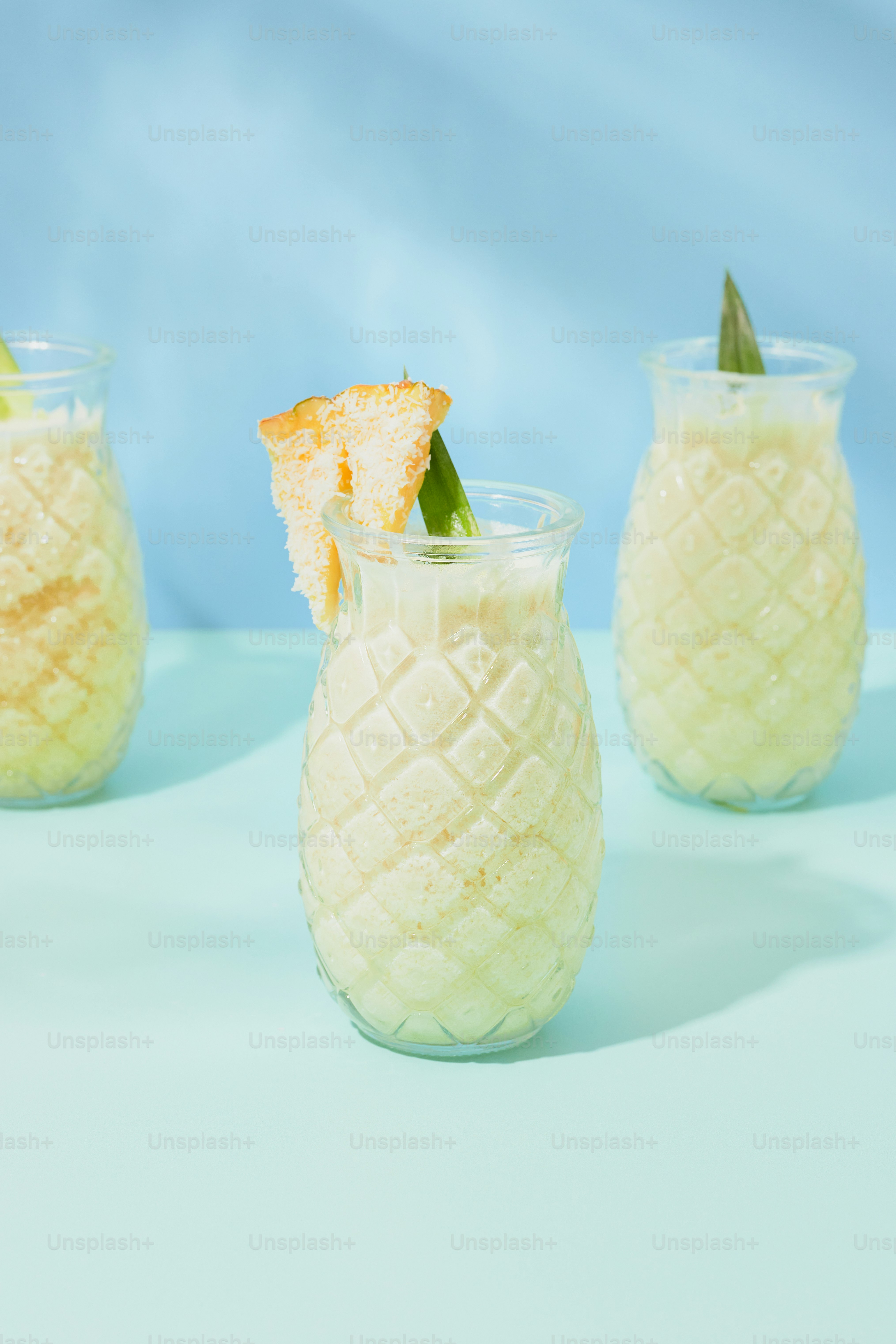 Three glasses filled with different types of drinks