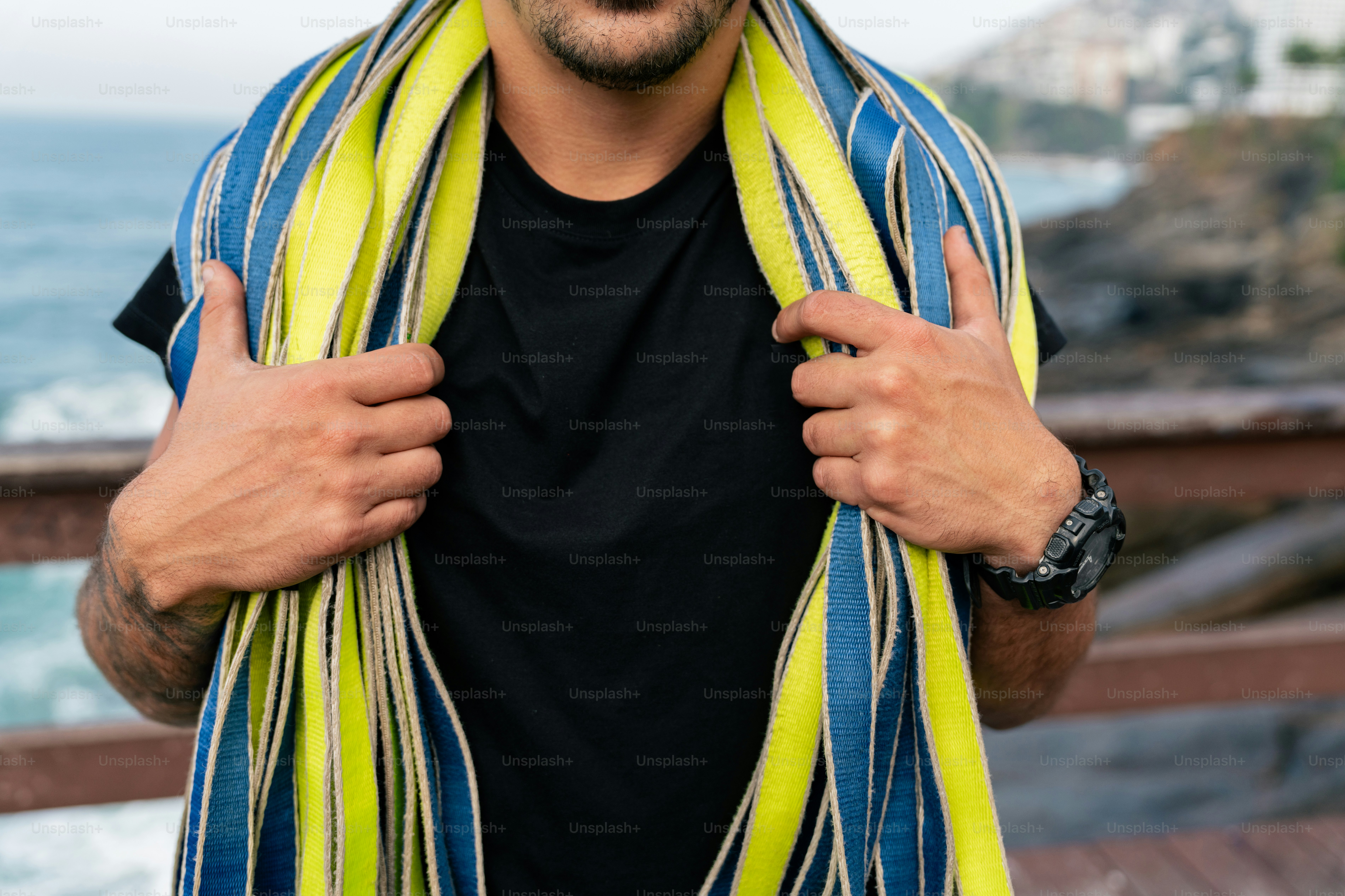 Un uomo con una camicia nera e una sciarpa gialla e blu