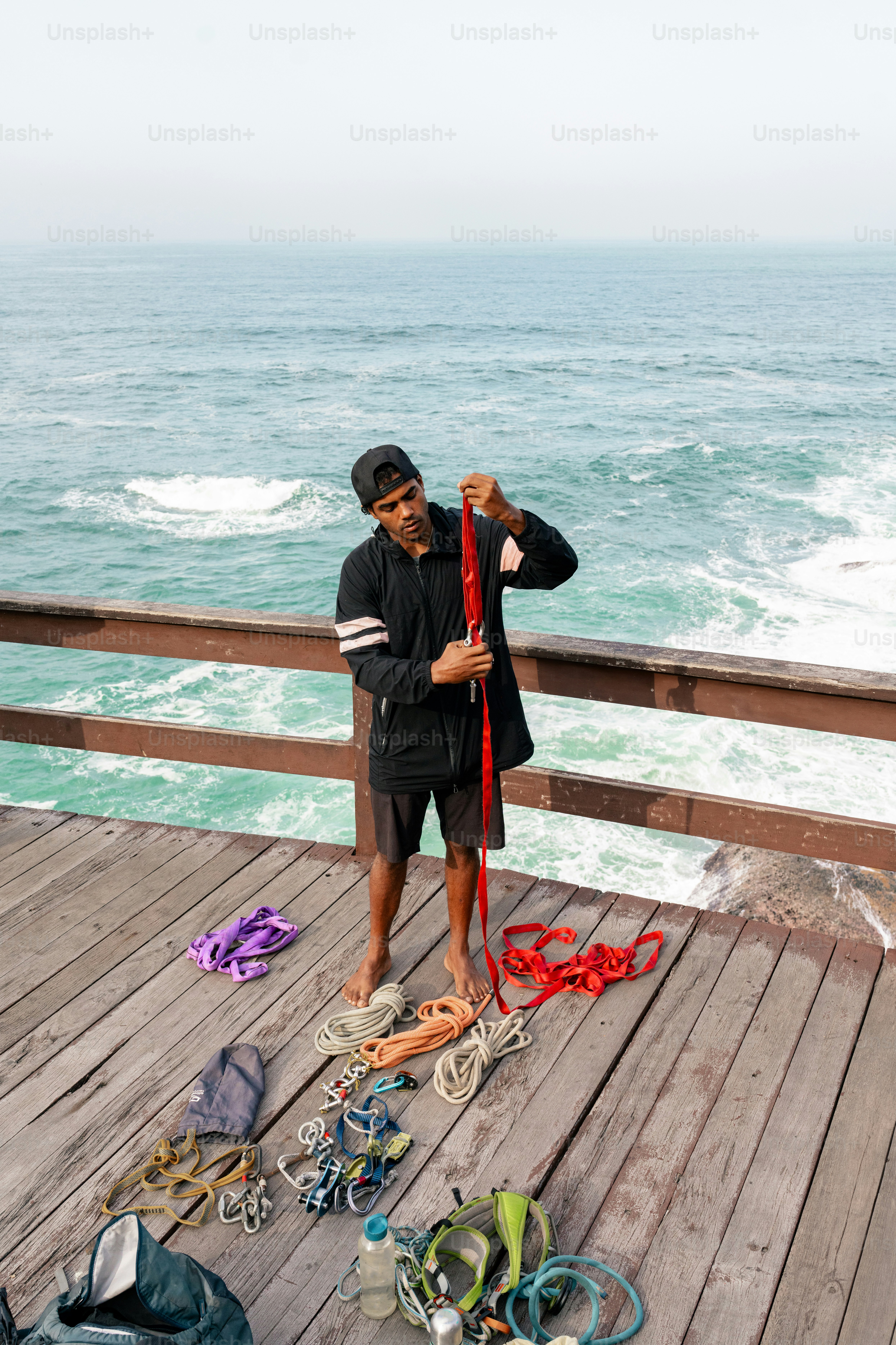 A man standing on a pier with a bunch of items