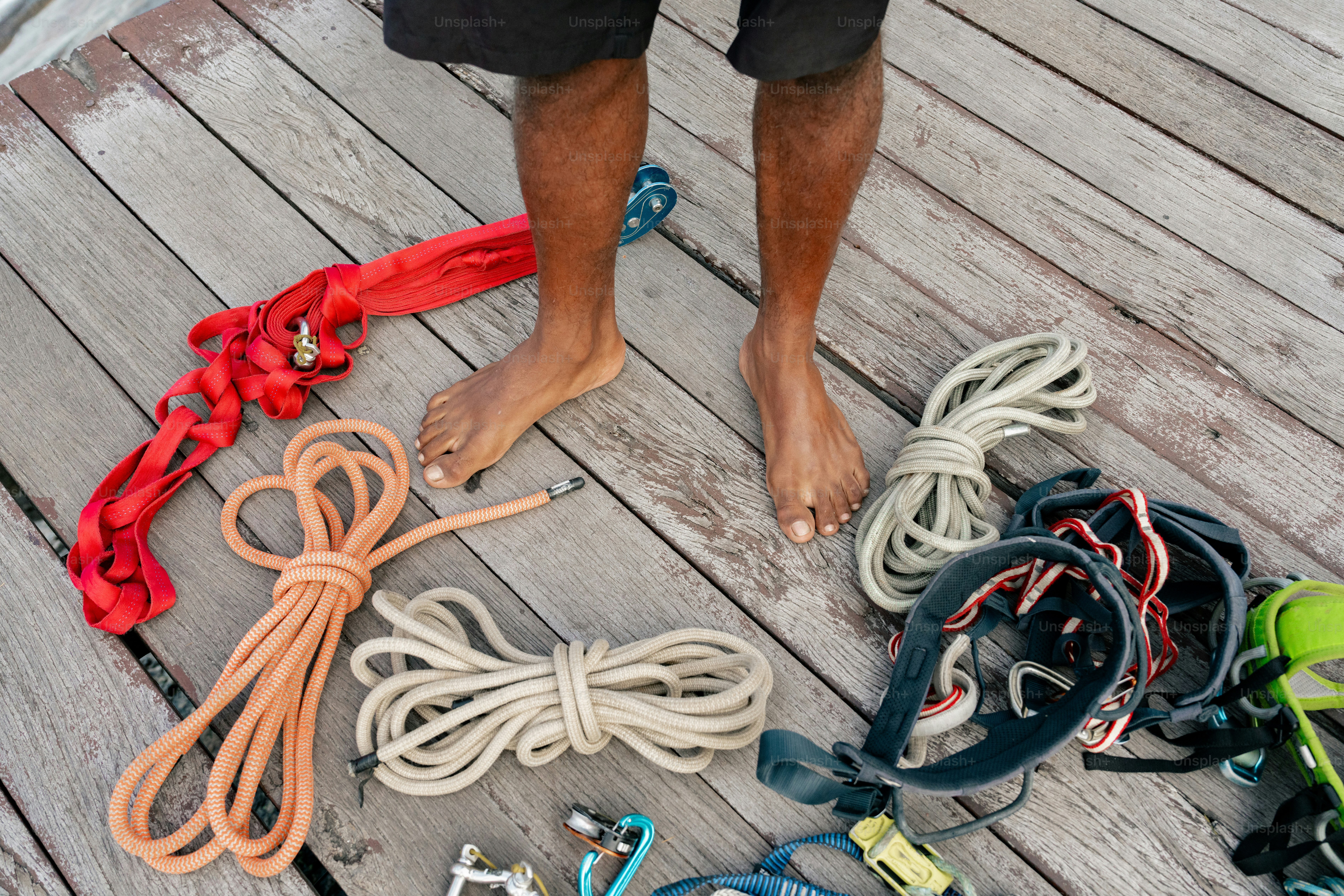 A man standing on a dock next to a bunch of rope