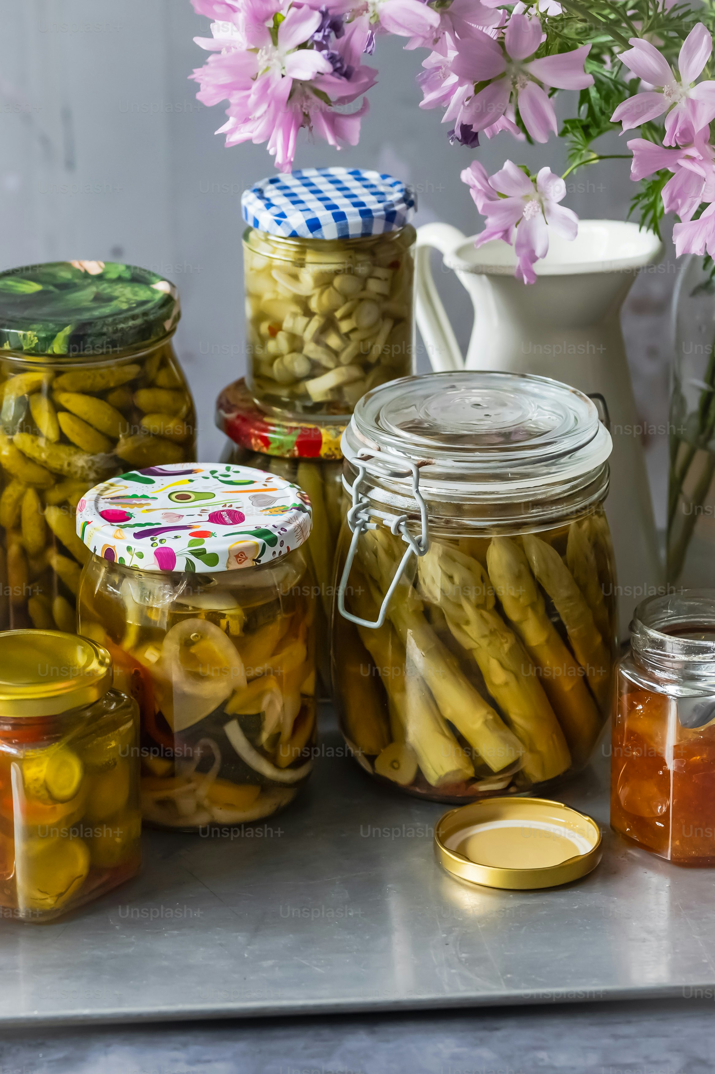 Una mesa cubierta con frascos llenos de pepinillos