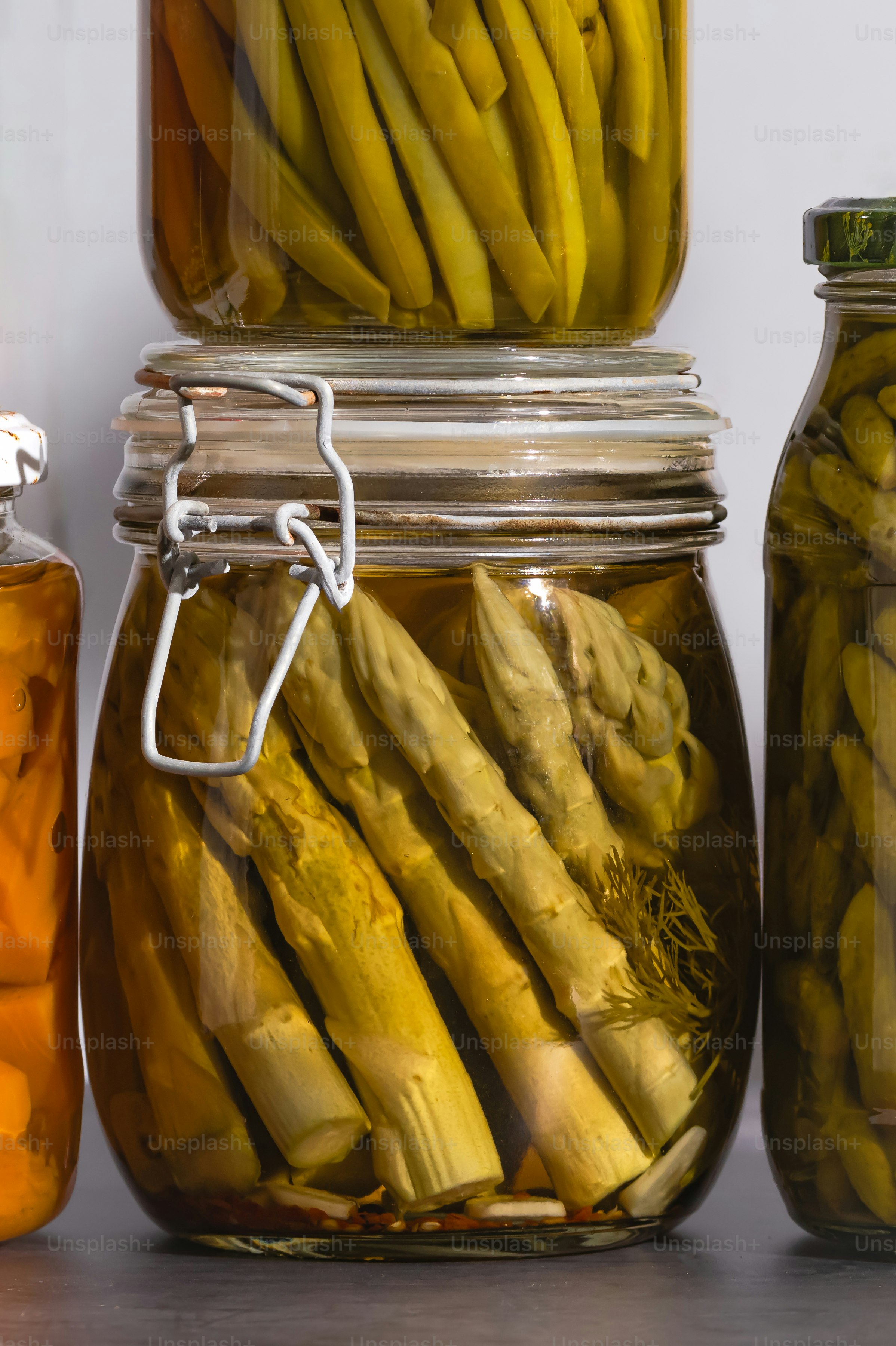 Frascos llenos de pepinillos y otros alimentos