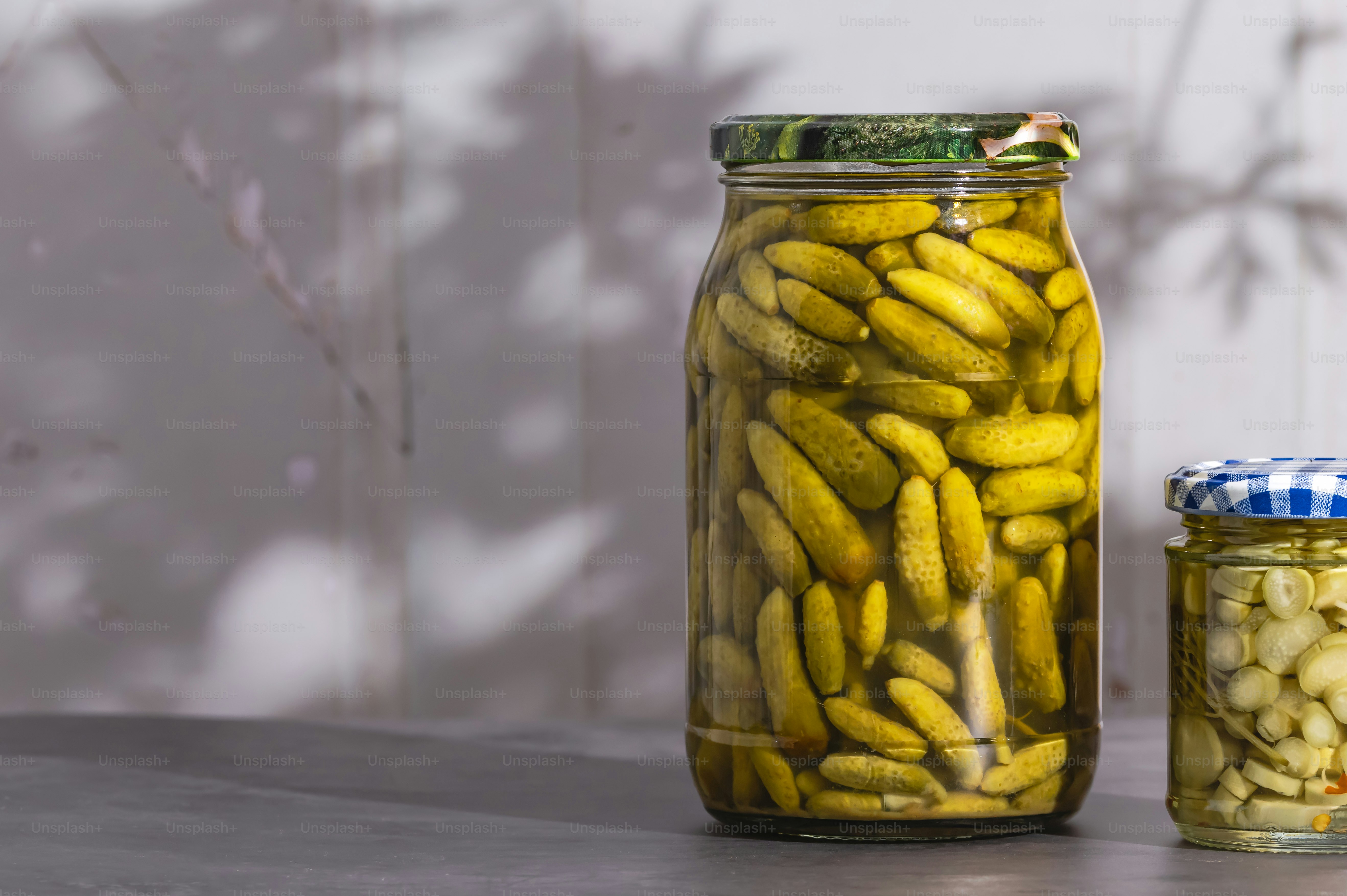 A jar of pickled bananas next to a jar of pickled almonds photo ...