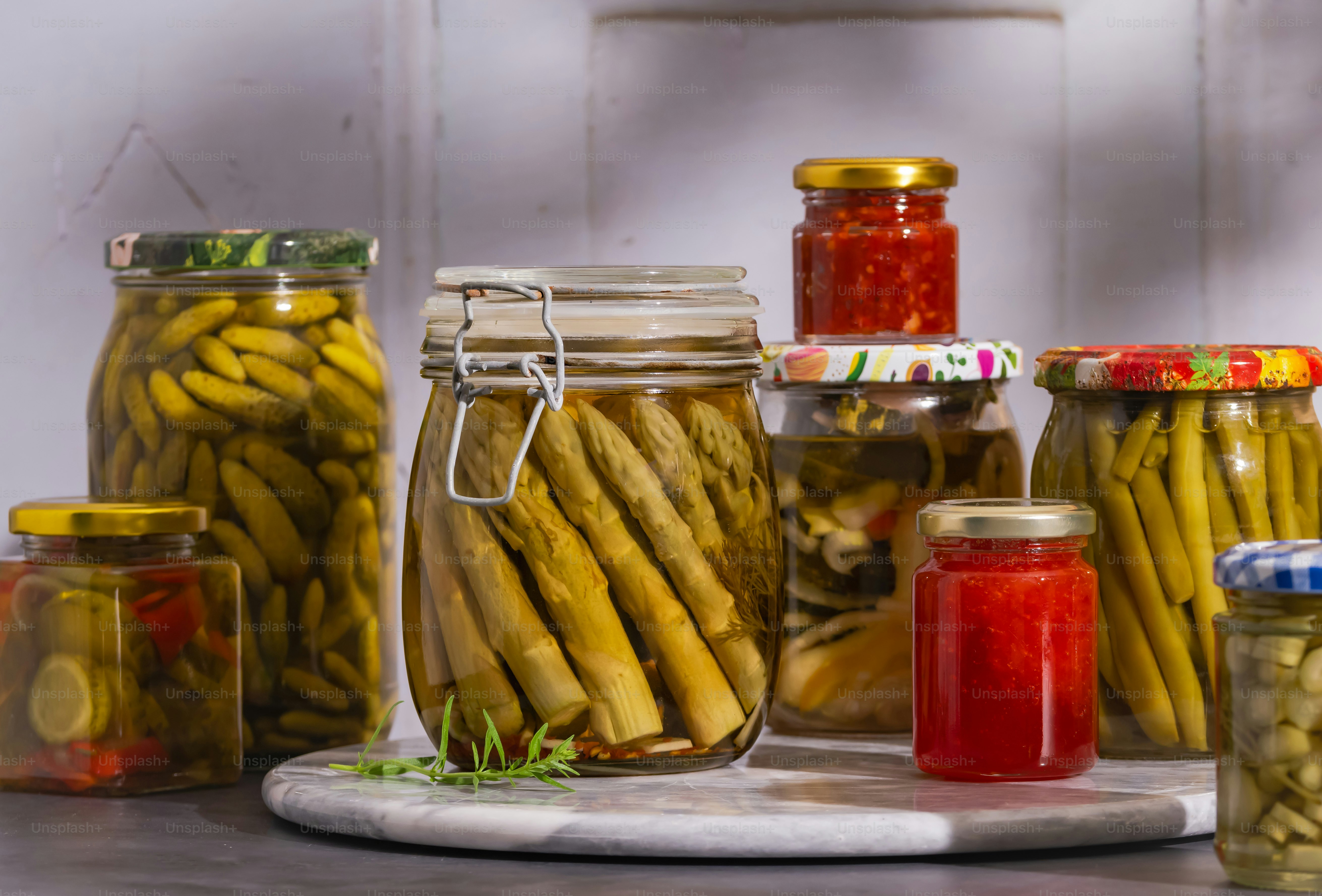 A table topped with jars filled with pickles and pickles