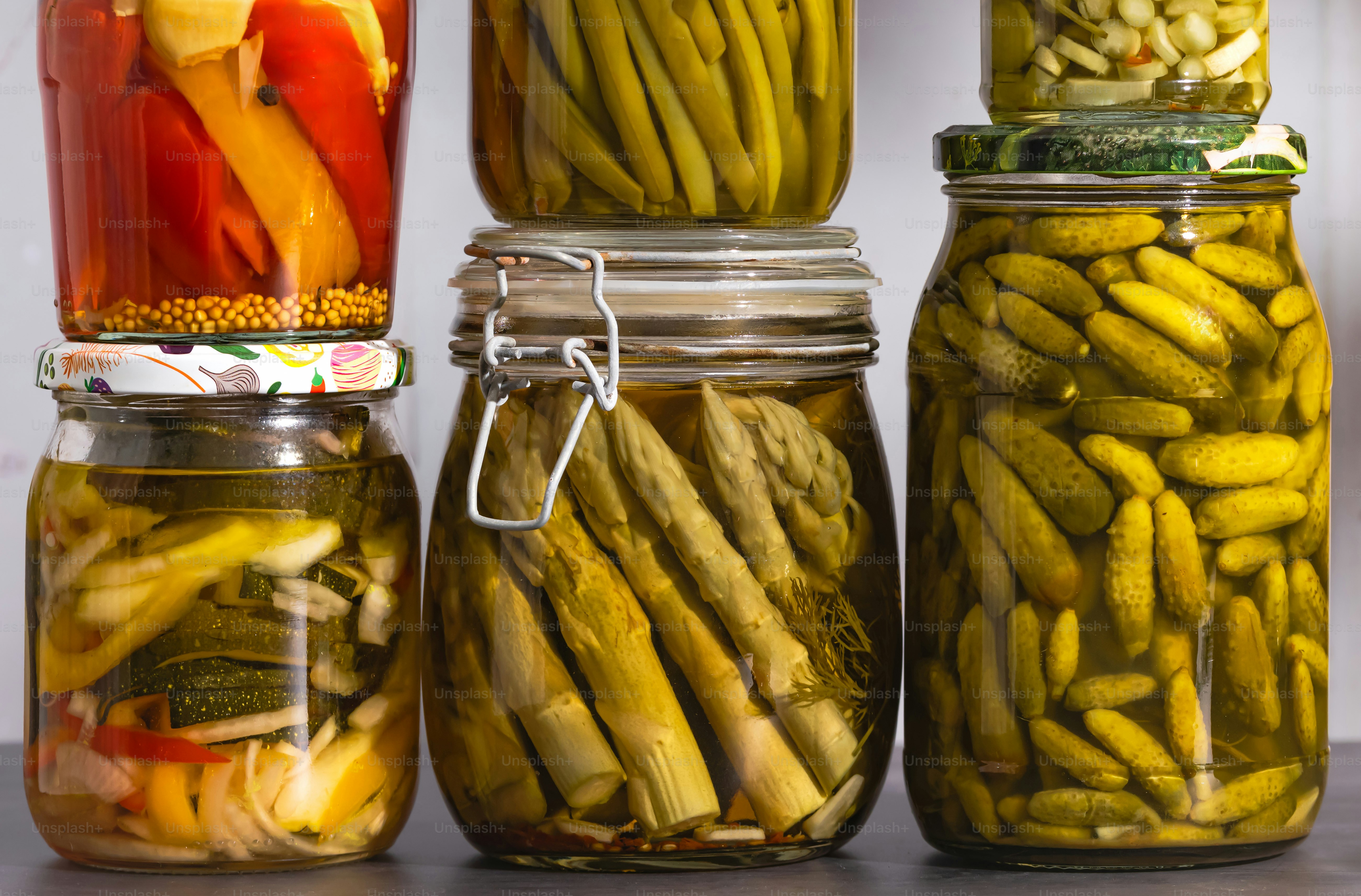 A group of jars filled with different types of pickles